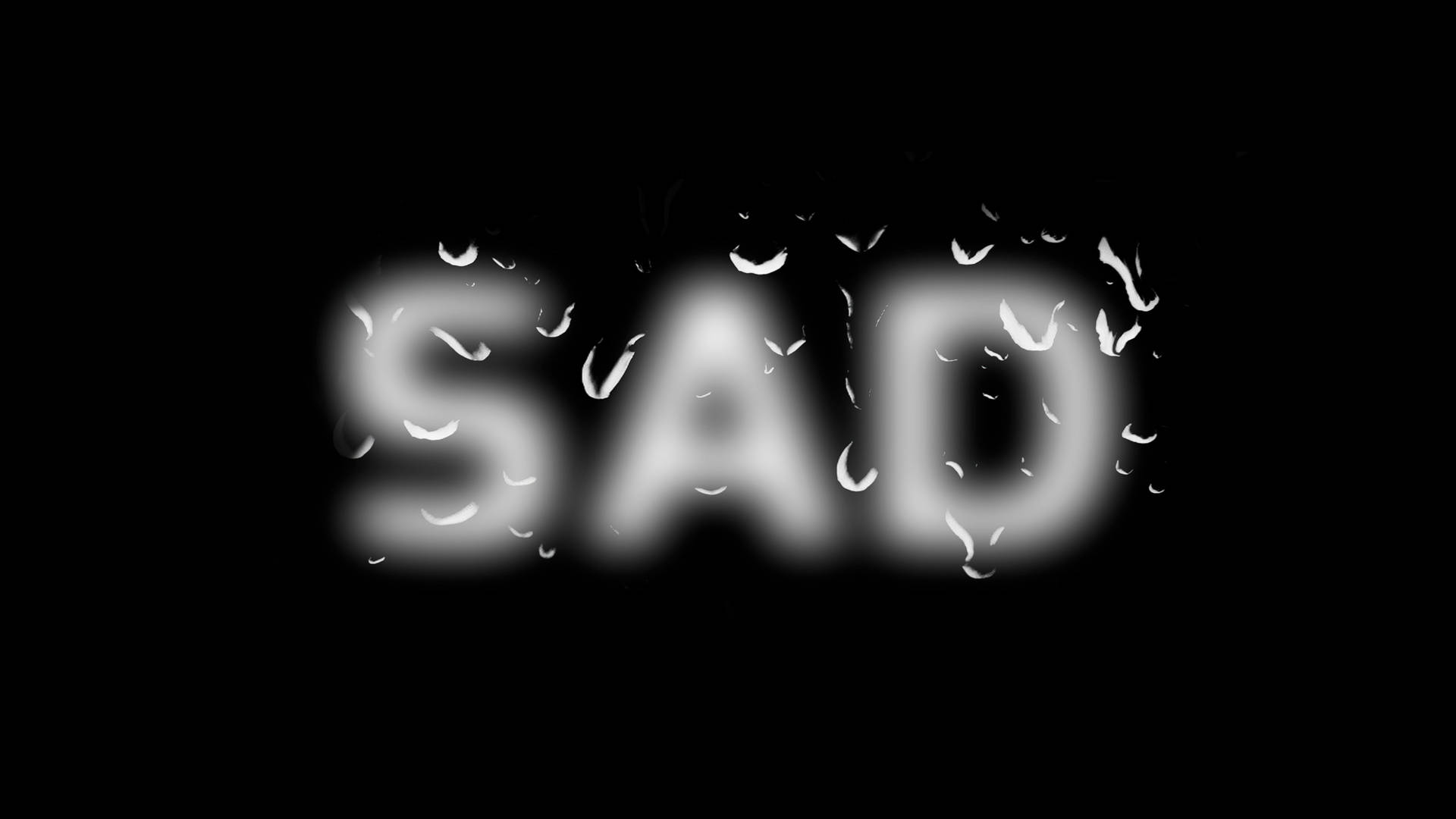 「SAD」呢個字上面有雨滴，背景係黑色。