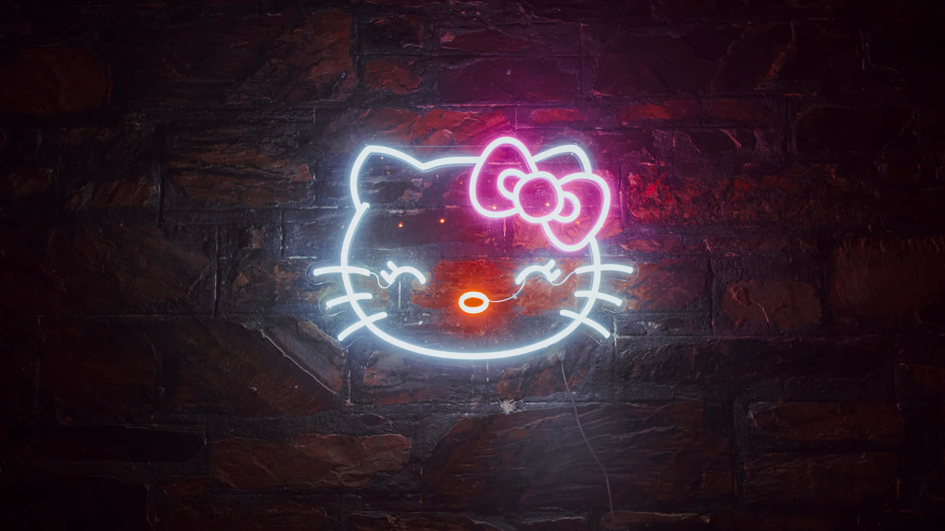 令人著迷的天空色彩旋轉 壁紙 — 一個發光的Hello Kitty霓虹燈牌，帶有粉紅色蝴蝶結和橙色鼻子，在深色磚牆上投射出鮮豔的光芒。