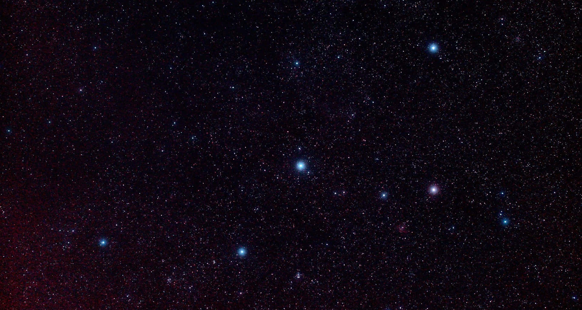 一個角落有微弱紅色星雲光芒的星空夜晚。