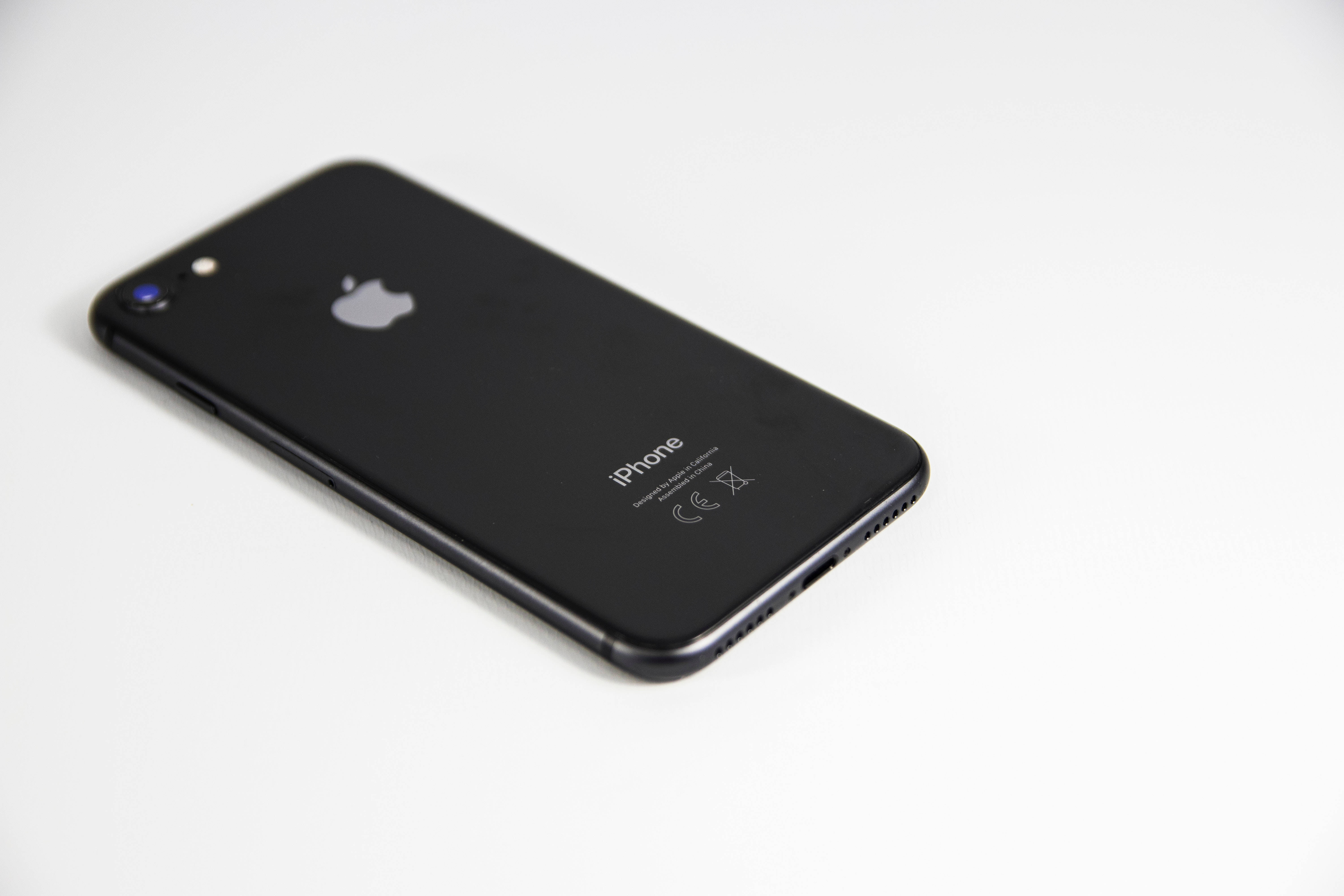 令人著迷的宇宙星系 iPhone 解鎖畫面 壁紙 — 一部時尚的黑色 iPhone 7 對角放置在潔白的表面上，柔和的光線突顯其光澤質感。