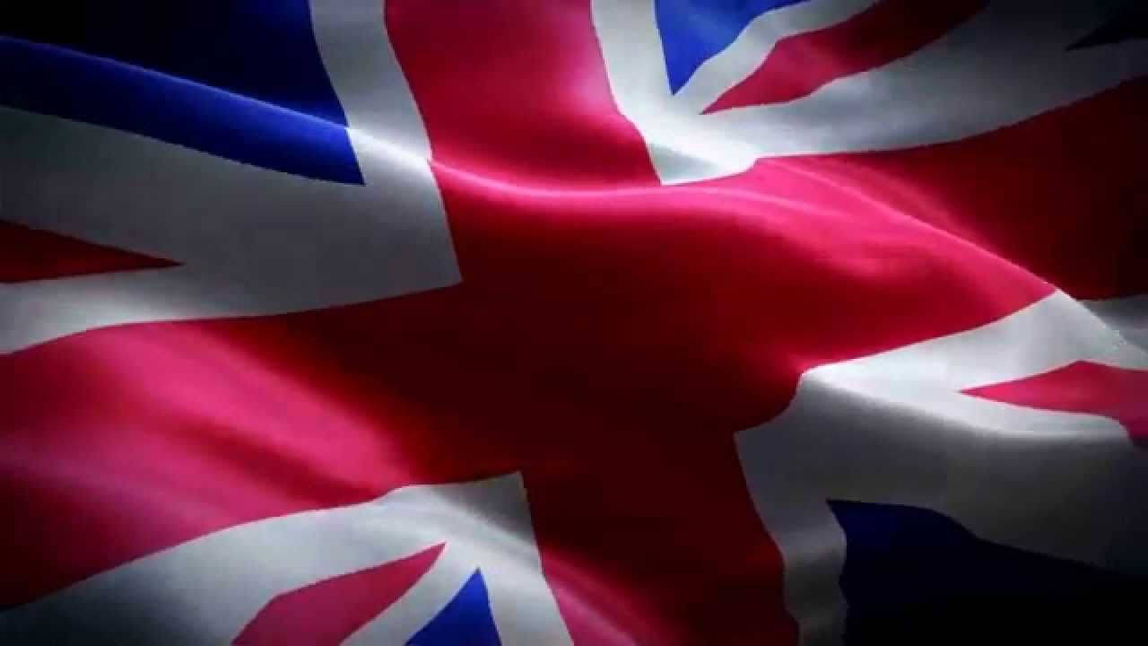 令人著迷的英國國旗展示 壁紙 — 英國國旗在戲劇性燈光下以豐富的紅、藍、白色動態飄揚的特寫。