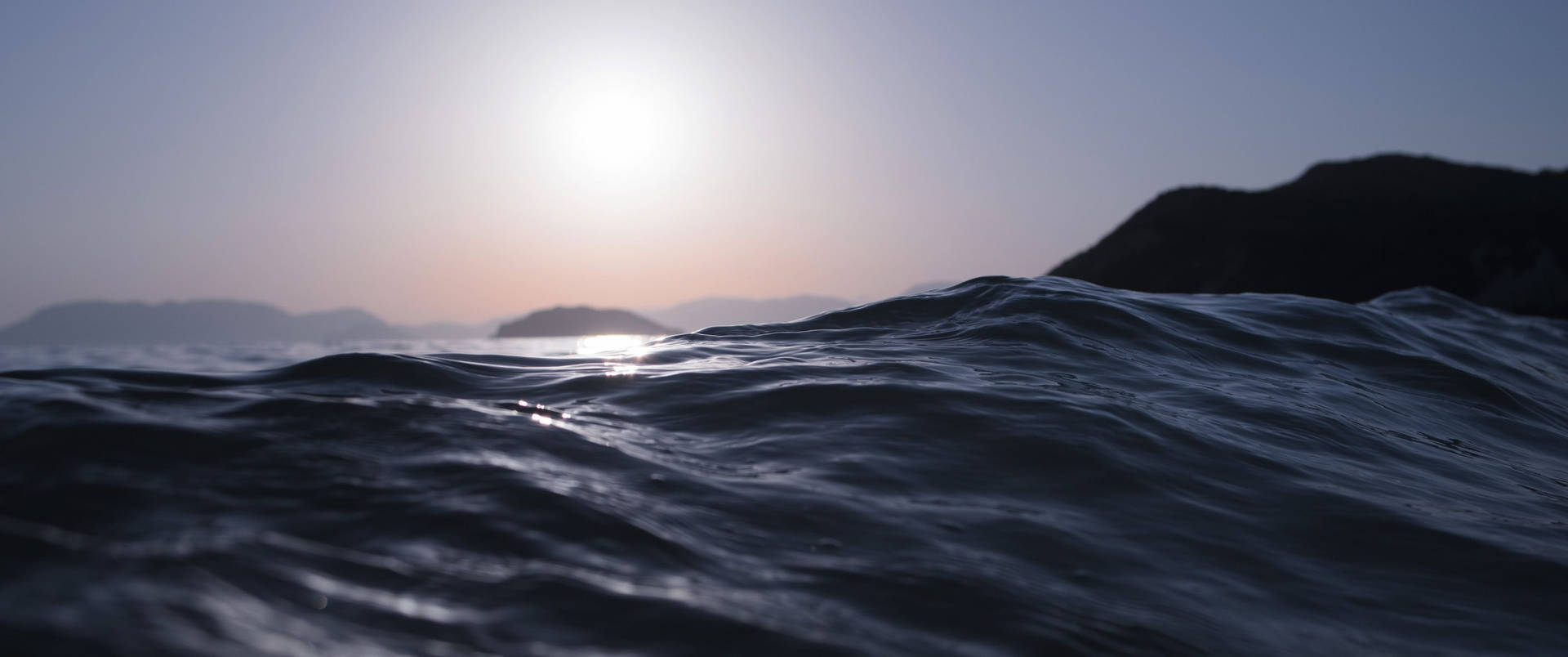 夕陽下的海浪與遠方山丘