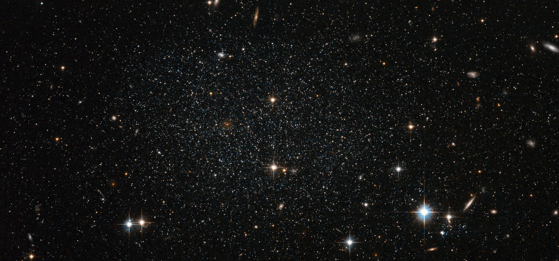 廣闊的星場，在深空中閃爍的恆星和暗淡的星系。