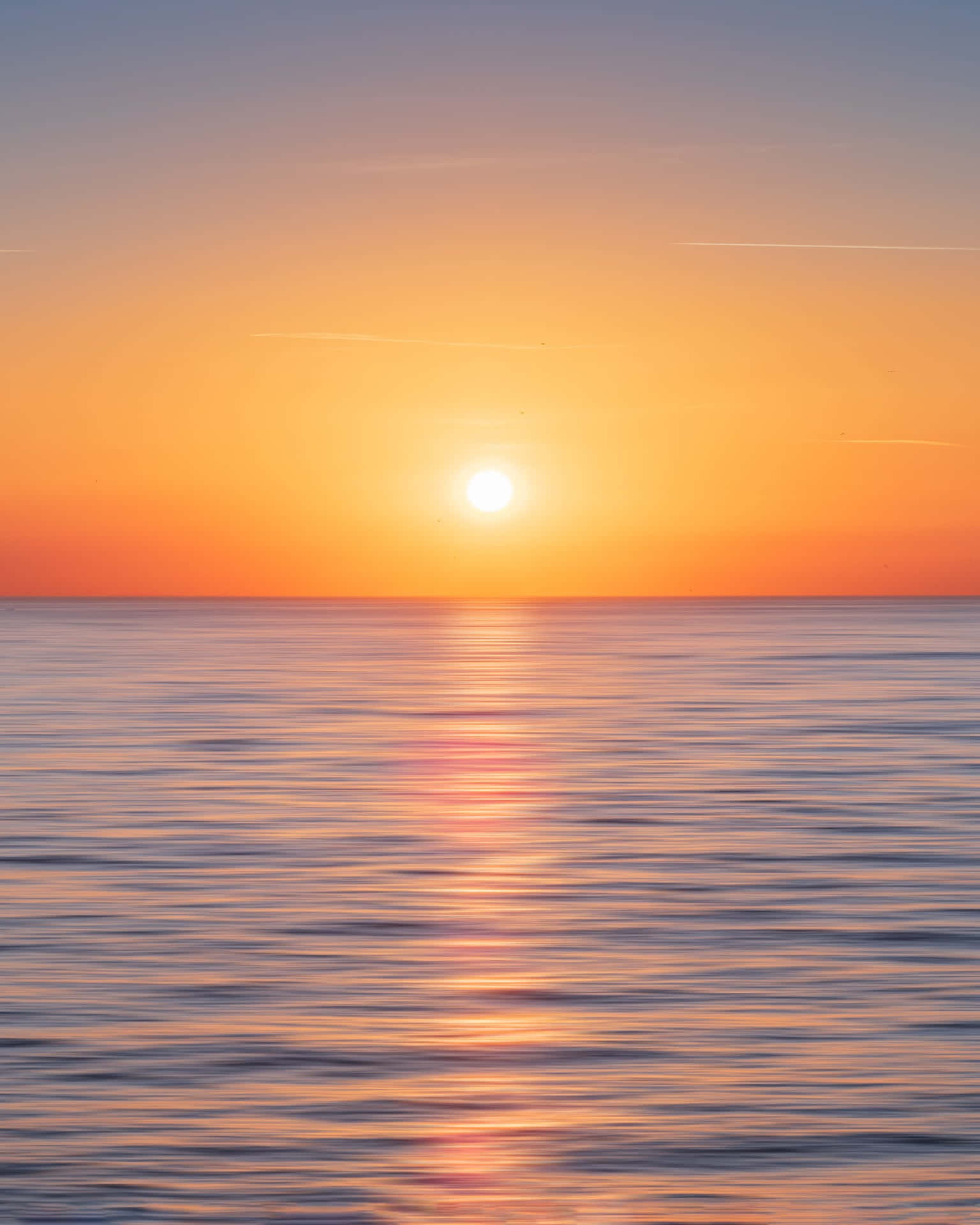 平靜海面上的日落，金色倒影