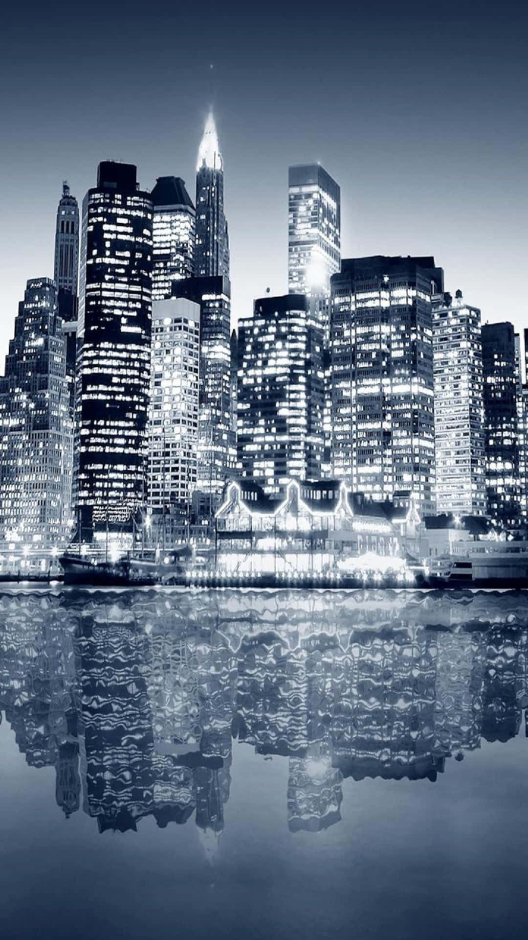 夜晚城市天際線，摩天大樓倒映在水中