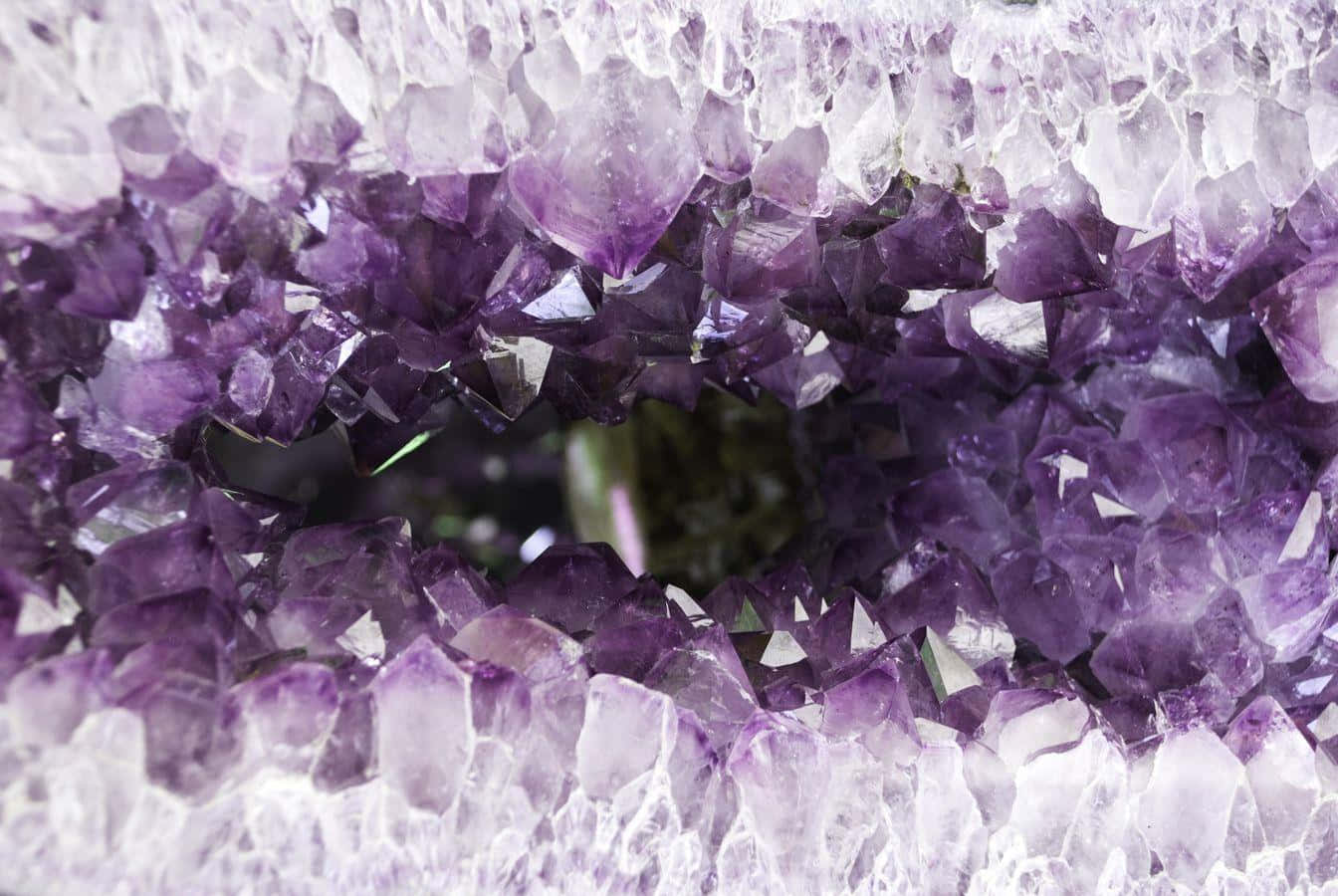 Amethyst 桌布 壁紙 — 令人驚嘆的紫水晶晶洞特寫，展現出閃閃發光的紫色晶體，中心有一個黑暗的空洞。