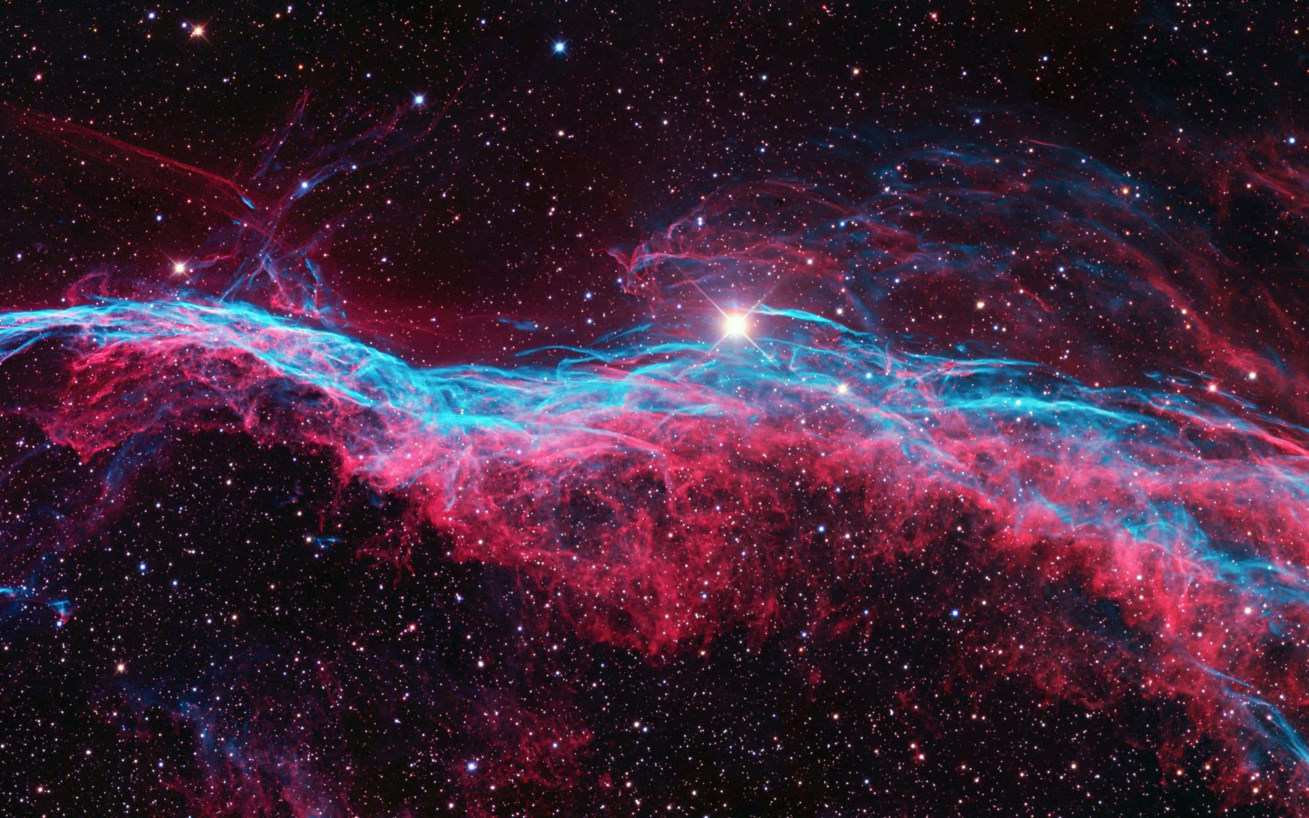 令人驚嘆的超新星爆發 壁紙 — 一個宇宙星雲在星空背景下以鮮豔的紅色和電光藍色旋轉，一顆明亮的中心恆星照亮了宇宙塵埃。