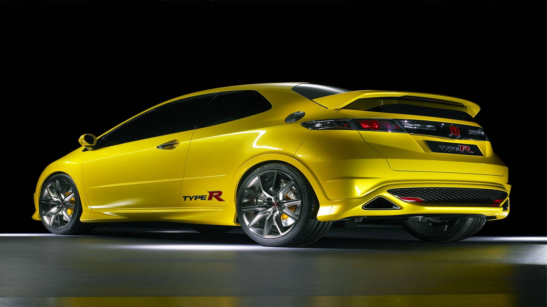 黃色本田 Type R 跑車在攝影棚內，配有反光地板和黑色背景。