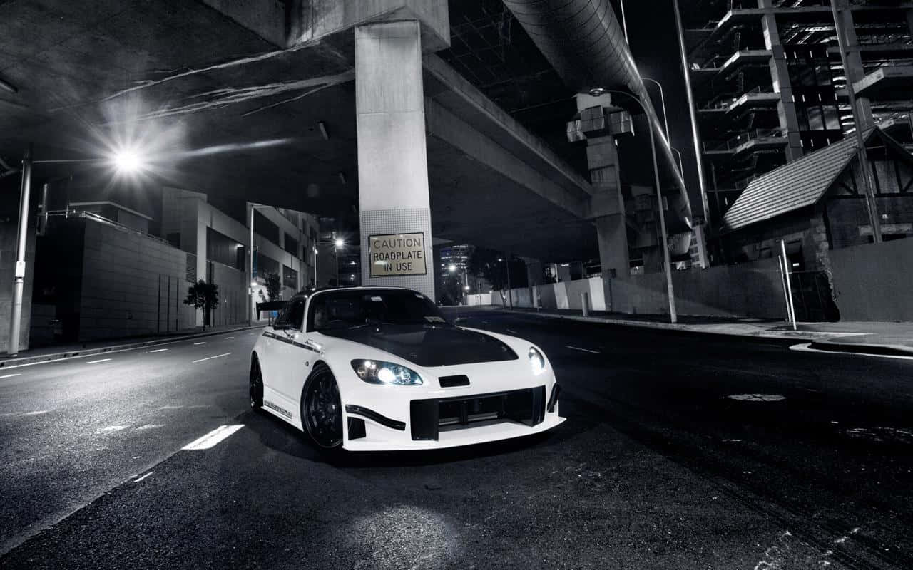 夜晚停在城市天橋下的白色改裝跑車。