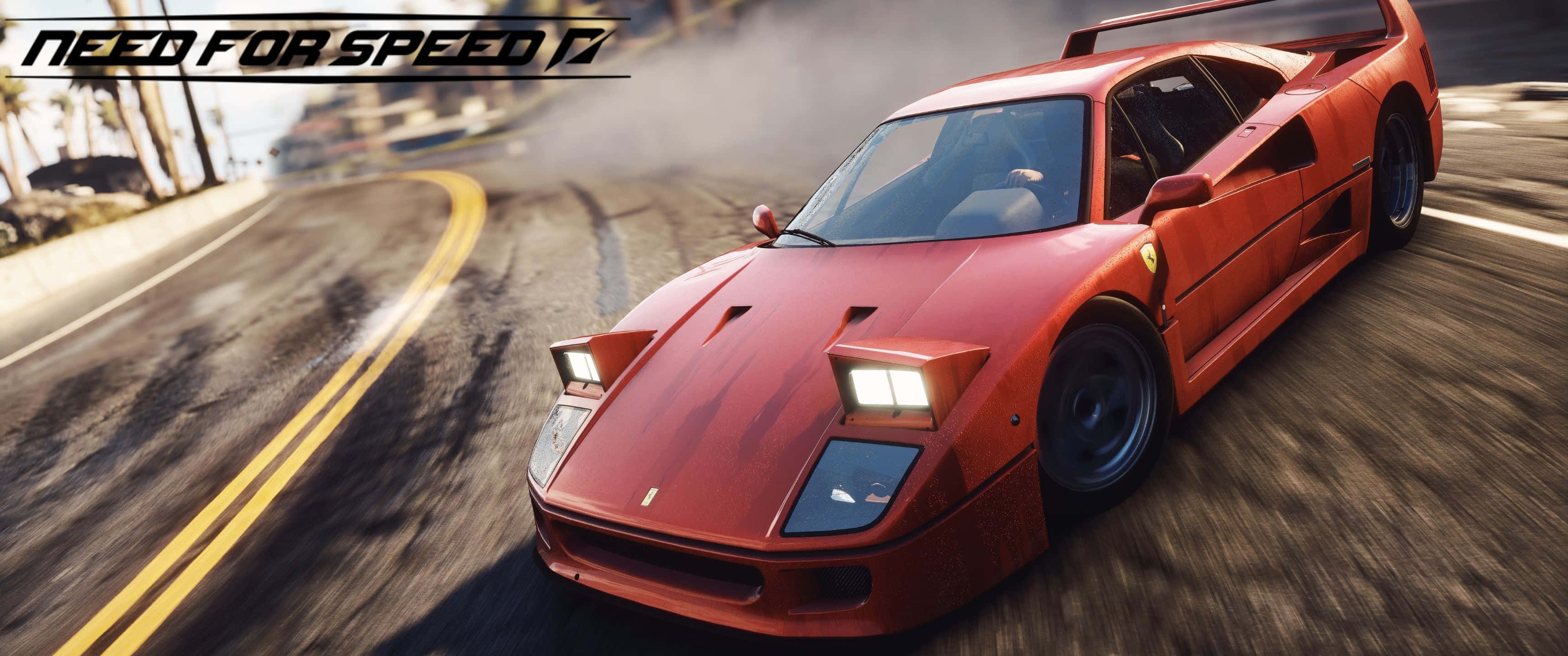 以 3440x1440p 解析度，駕馭《Need For Speed》的引擎 壁紙 — 一輛紅色法拉利F40在棕櫚樹環繞的海岸道路上飄移，動態模糊傳達高速感。