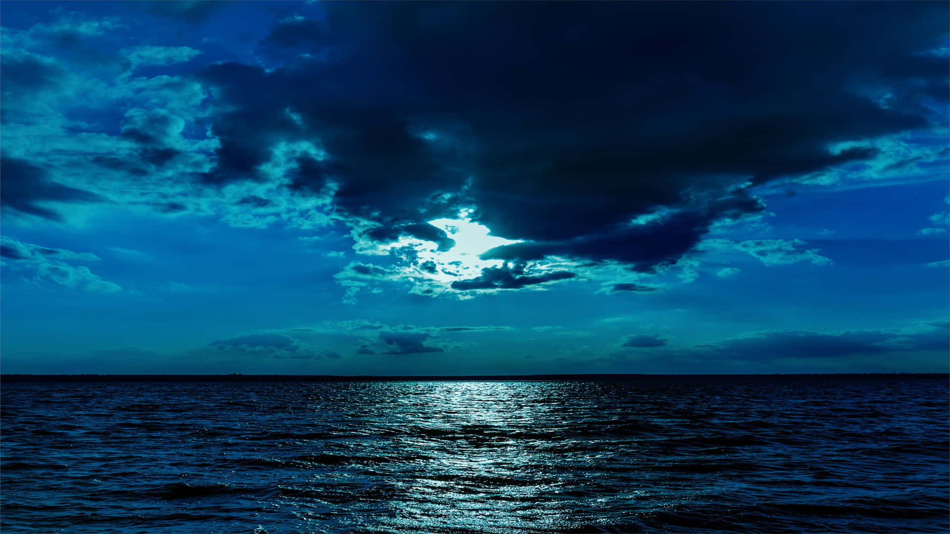 月光在陰暗的夜空下反射在黑暗的海浪上。