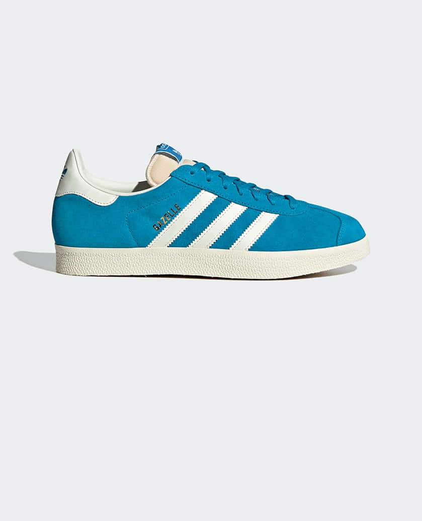 以 Adidas 獲取靈感 壁紙 — 一雙充滿活力的藍色 adidas Gazelle 運動鞋，帶有白色條紋和鞋帶，在乾淨的攝影棚燈光下展示。