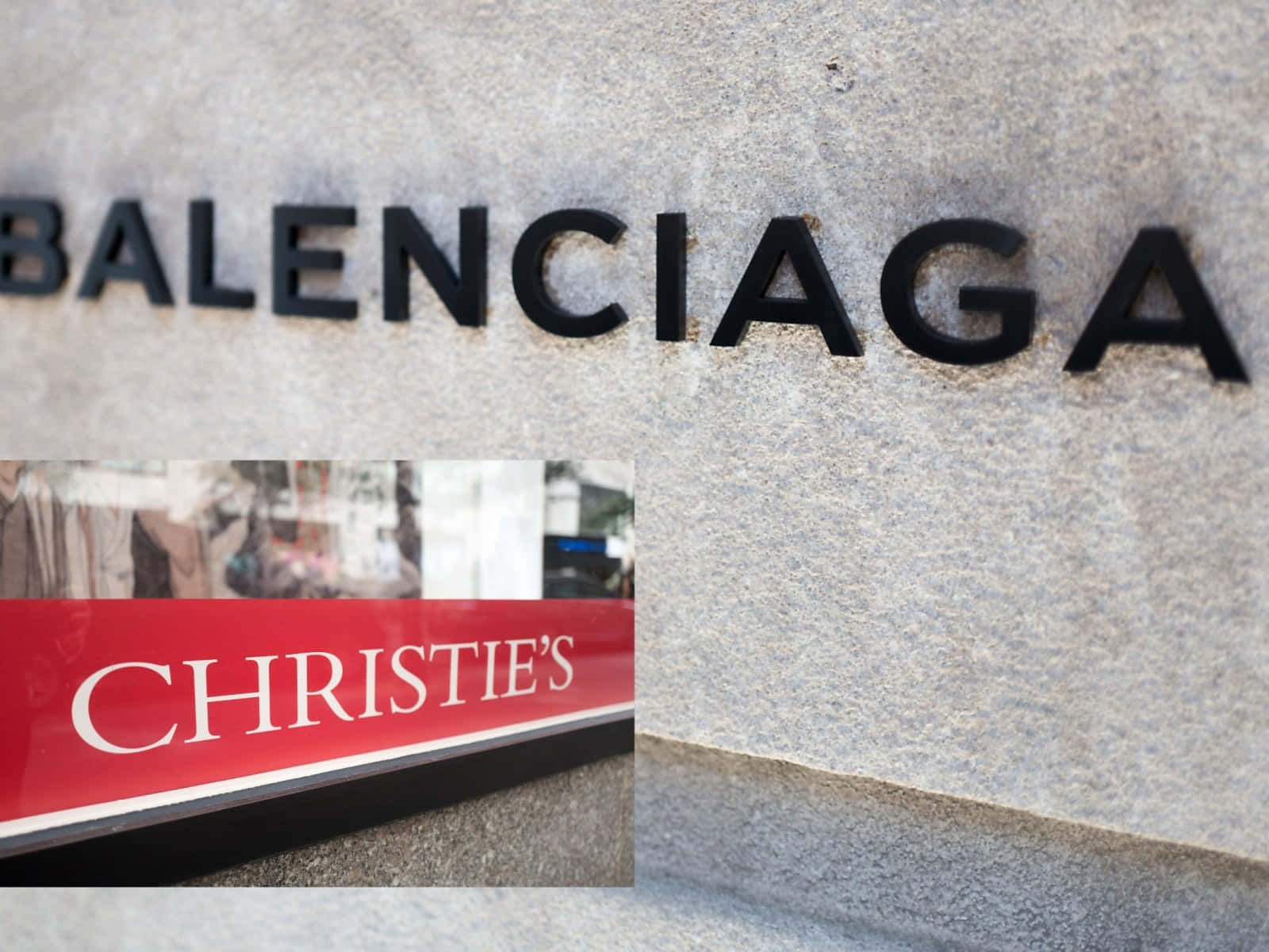 以 Balenciaga 塑造個人風格 壁紙 — Balenciaga 和 Christie's 標誌的特寫，位於紋理石牆上，下方有反光窗戶。
