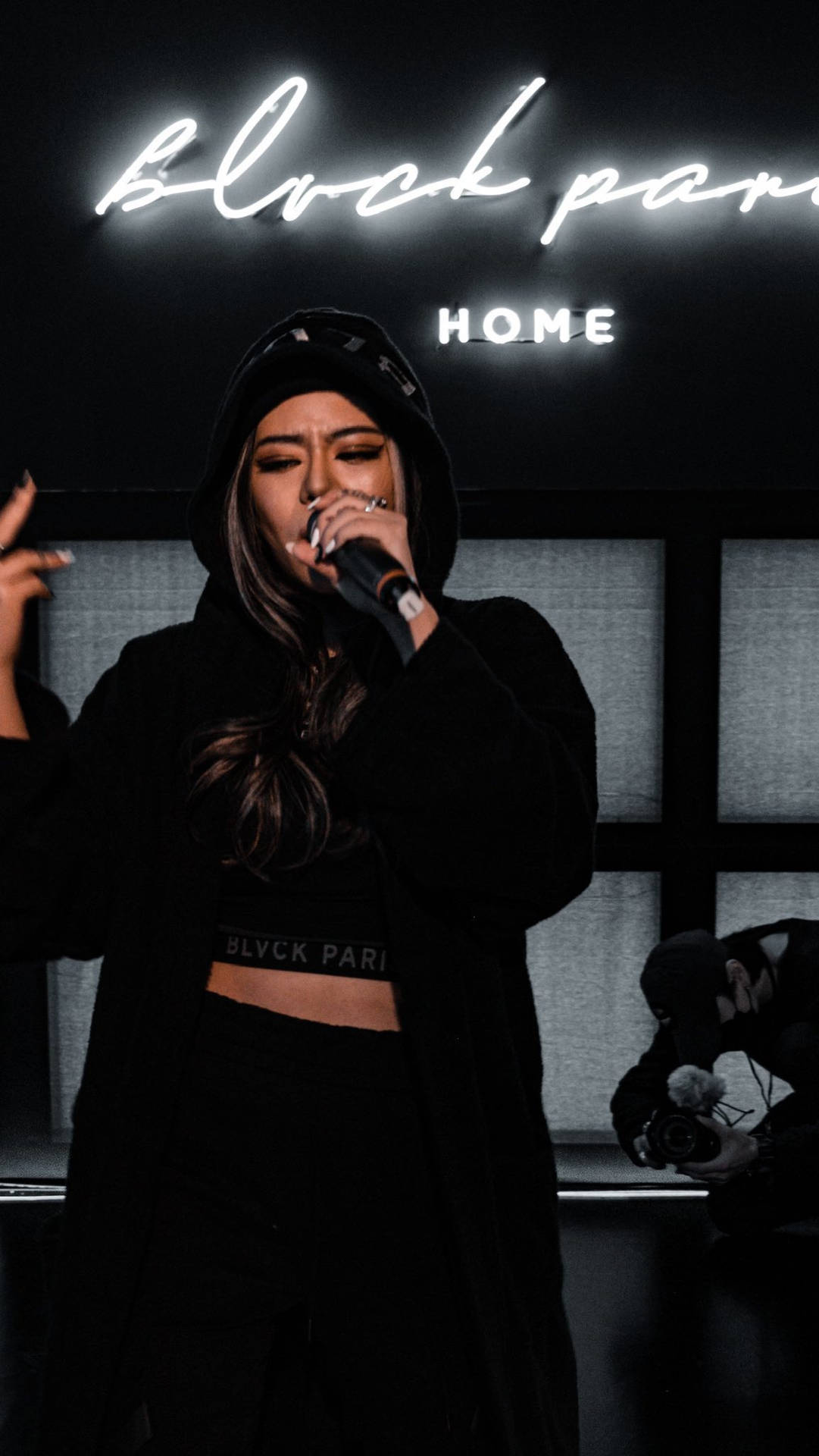 女歌手在block party home場地的霓虹燈下於舞台上表演。