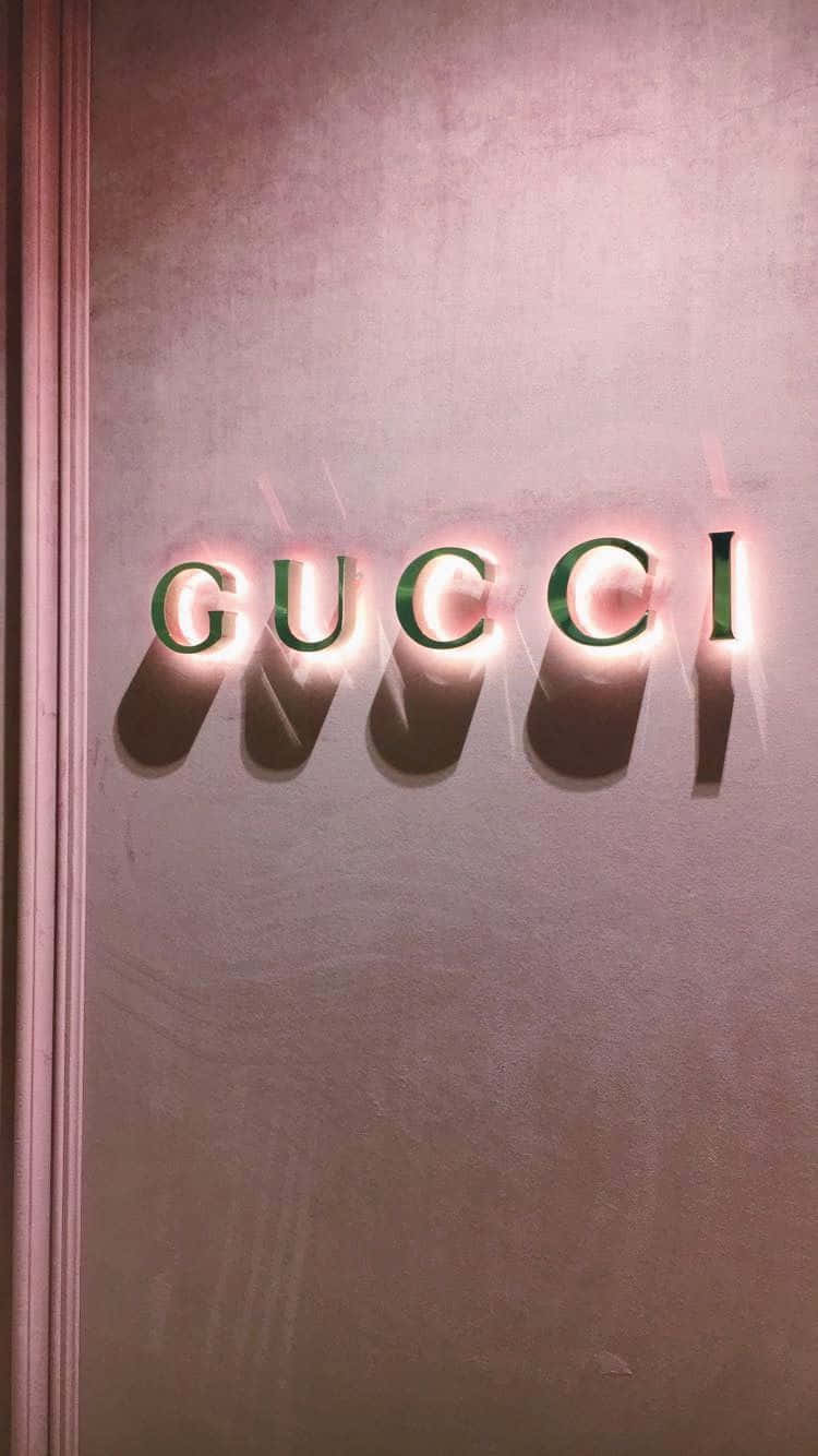 Gucci 標誌字母在帶有紋理的粉紅色牆壁上發光。