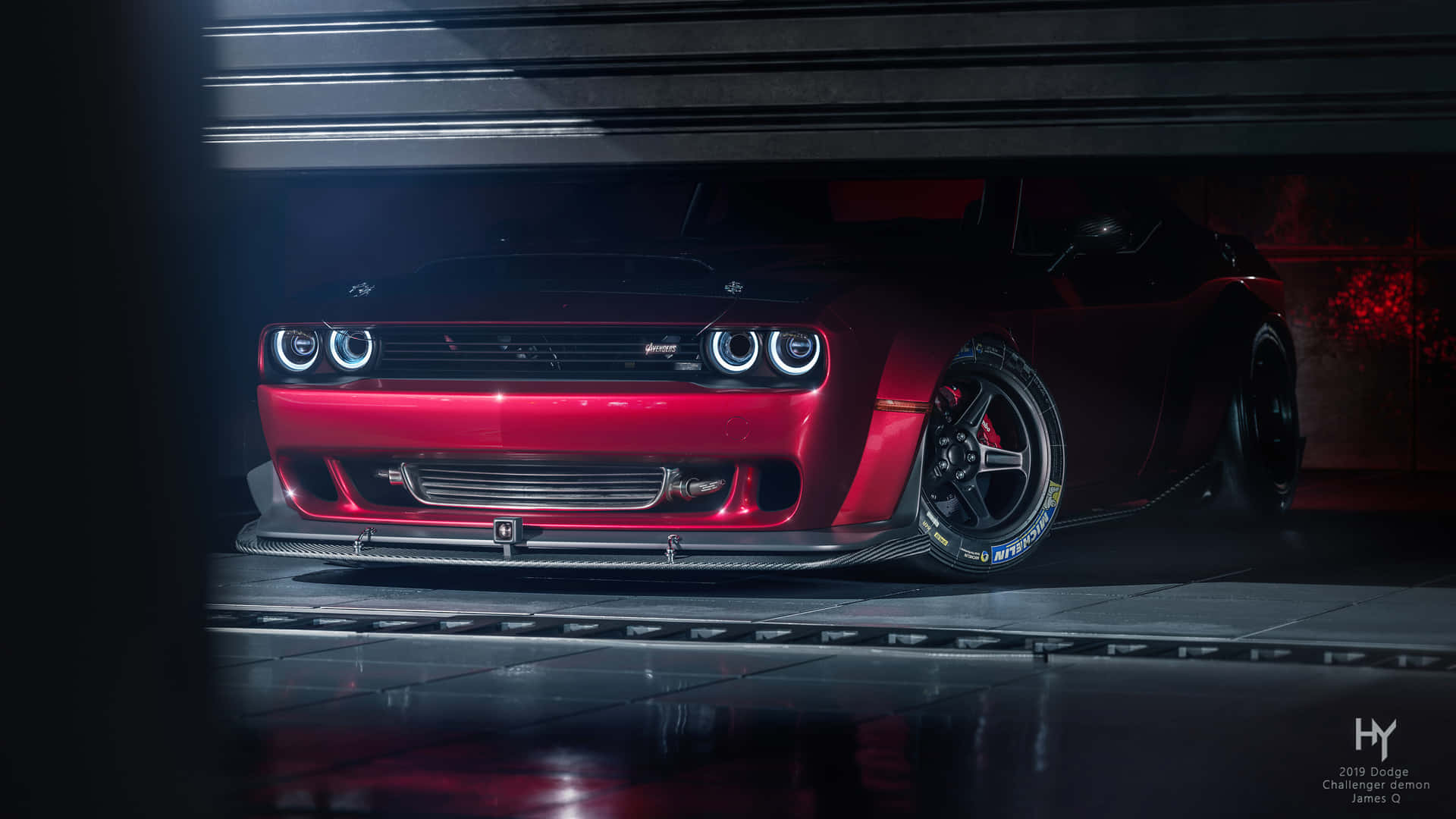紅色 Dodge Challenger SRT Hellcat 在昏暗的車庫中，頭燈發光。