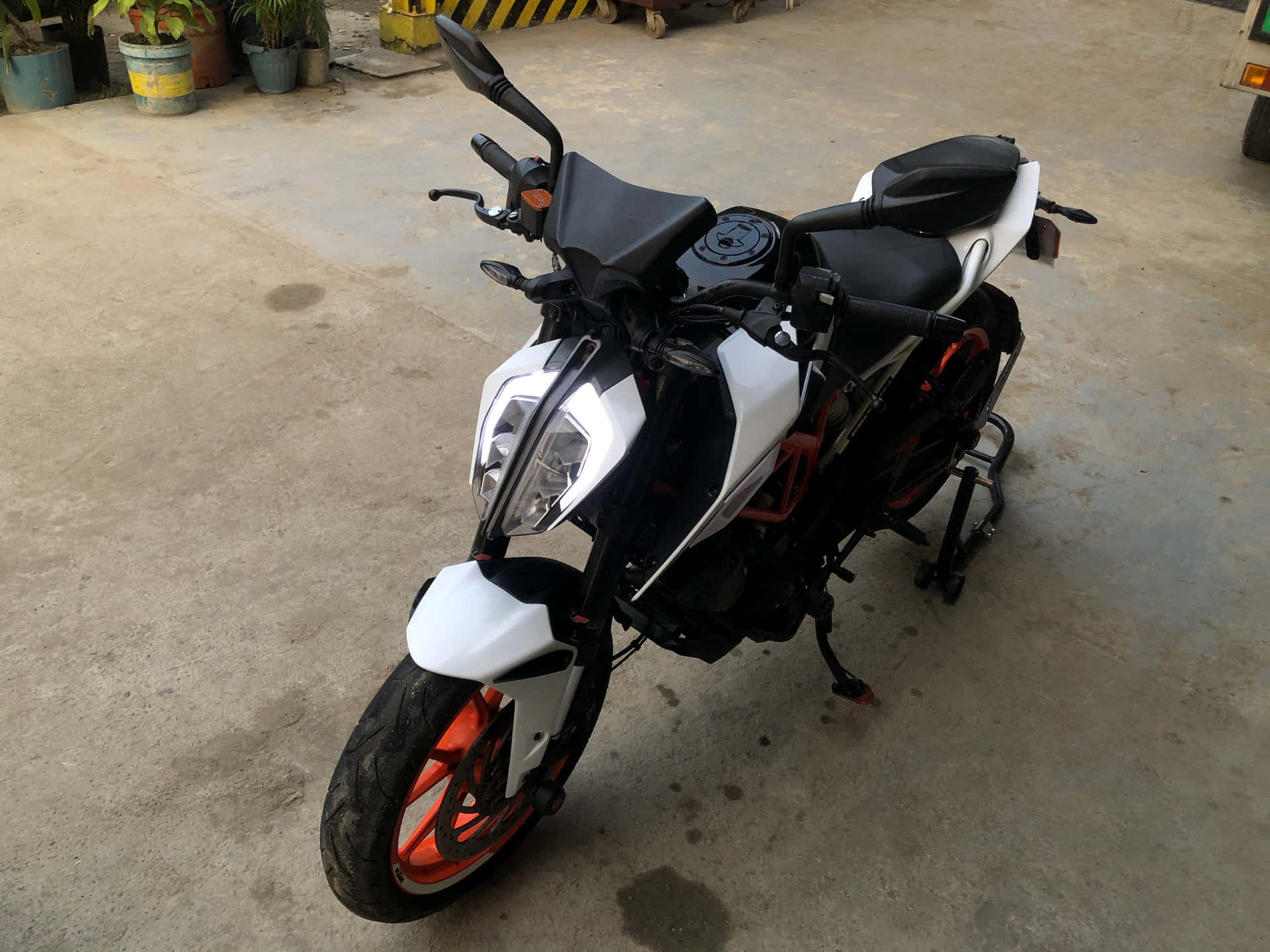 一架黑白運動型電單車配橙色輪胎，停放在室內。
