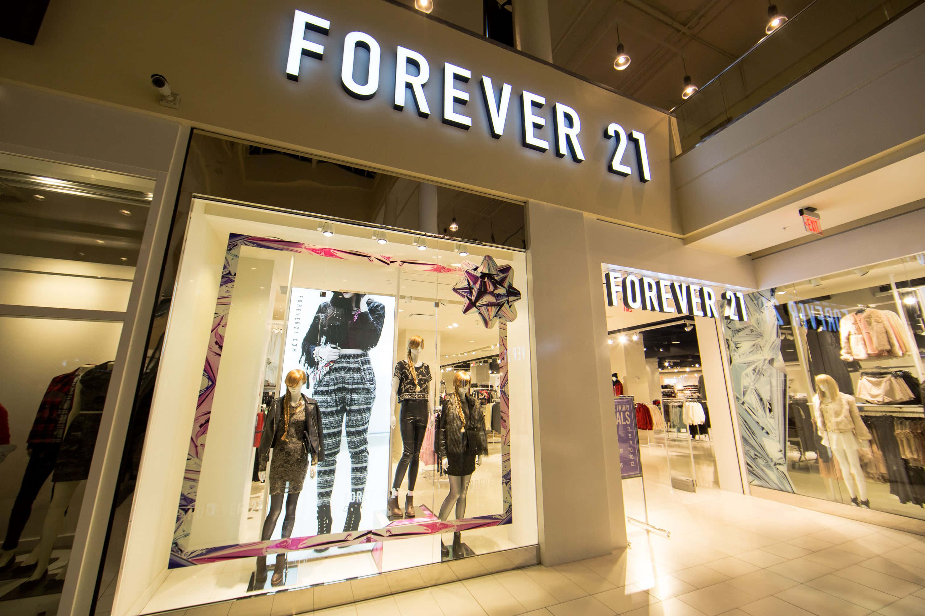 以 Forever 21 時尚設計師推薦系列打造完美造型 壁紙 — 商場內Forever 21店舖入口燈光明亮，櫥窗內展示穿著時尚服裝的人體模型。