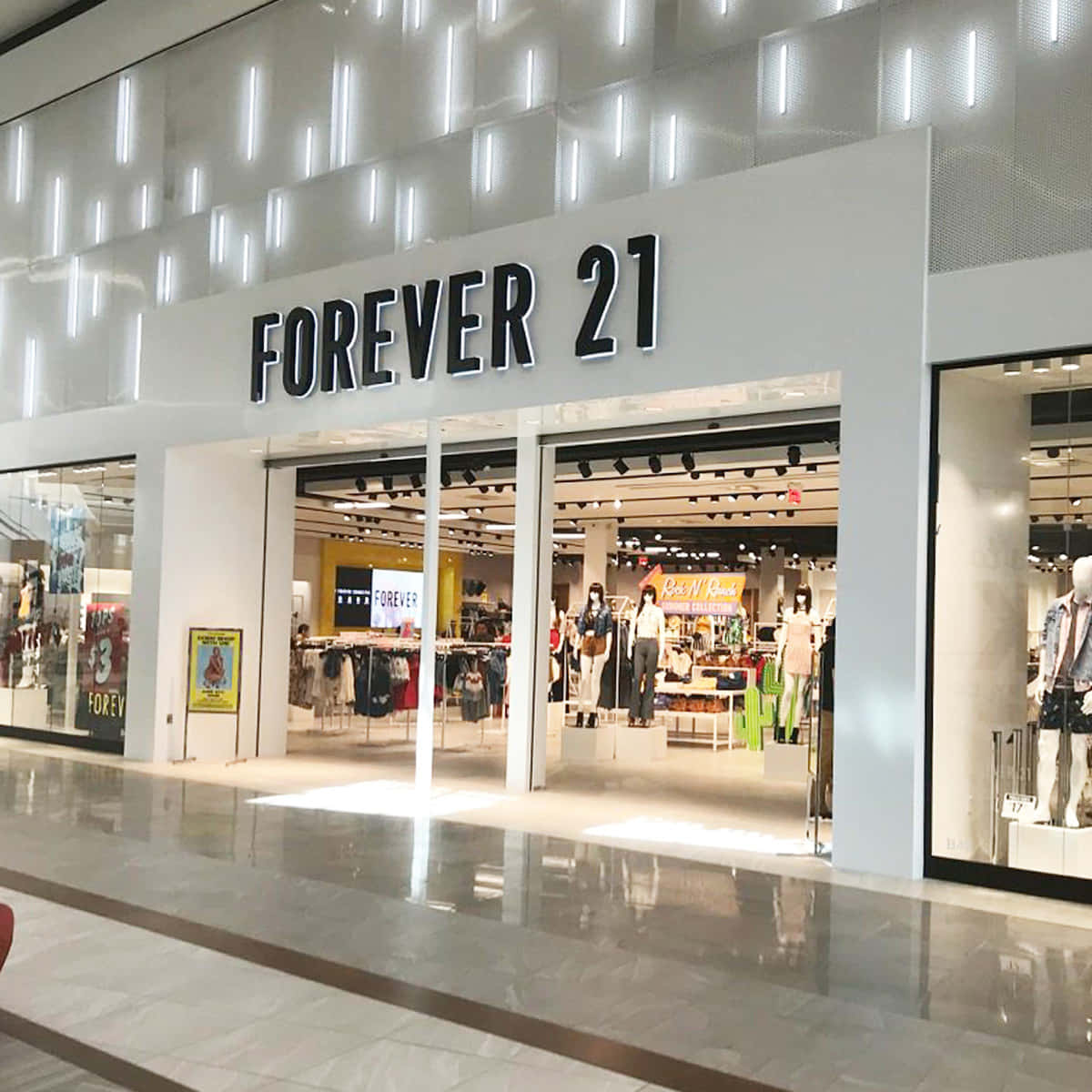 以 Forever 21 最新系列迎接春日時尚 壁紙 — 商場內明亮的Forever 21店舖入口，設有玻璃門和展示色彩繽紛服裝的人體模型，採用現代照明。