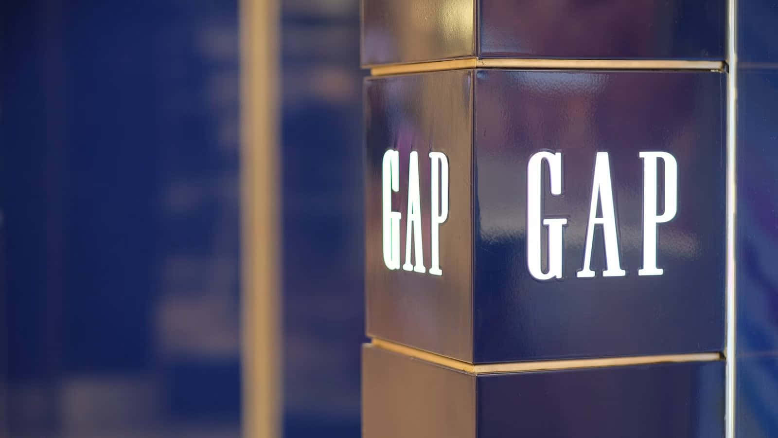 城市環境中帶有藍色面板和金色邊框的GAP零售店招牌。