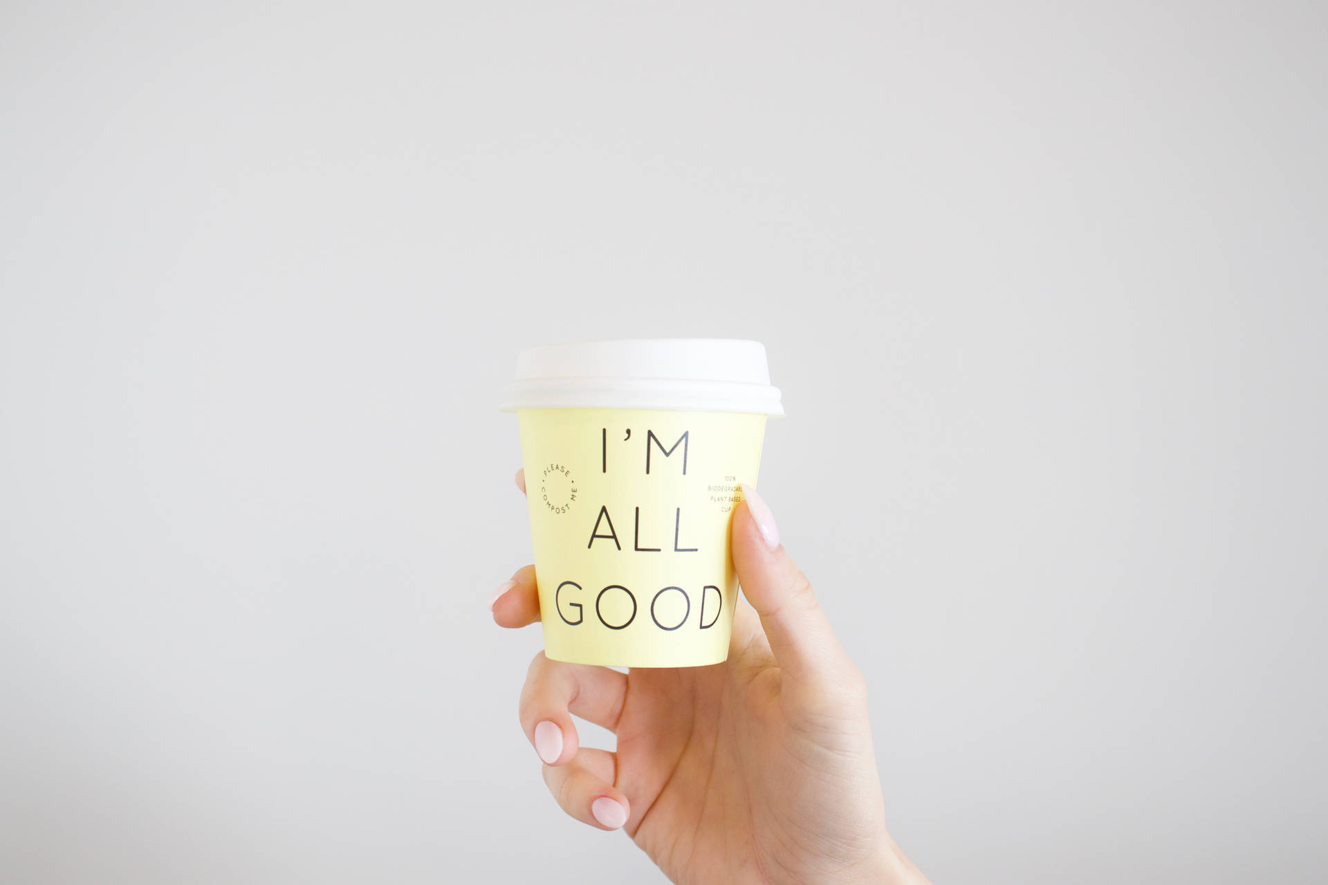 手拿著一個黃色咖啡杯，訊息為I'm All Good。