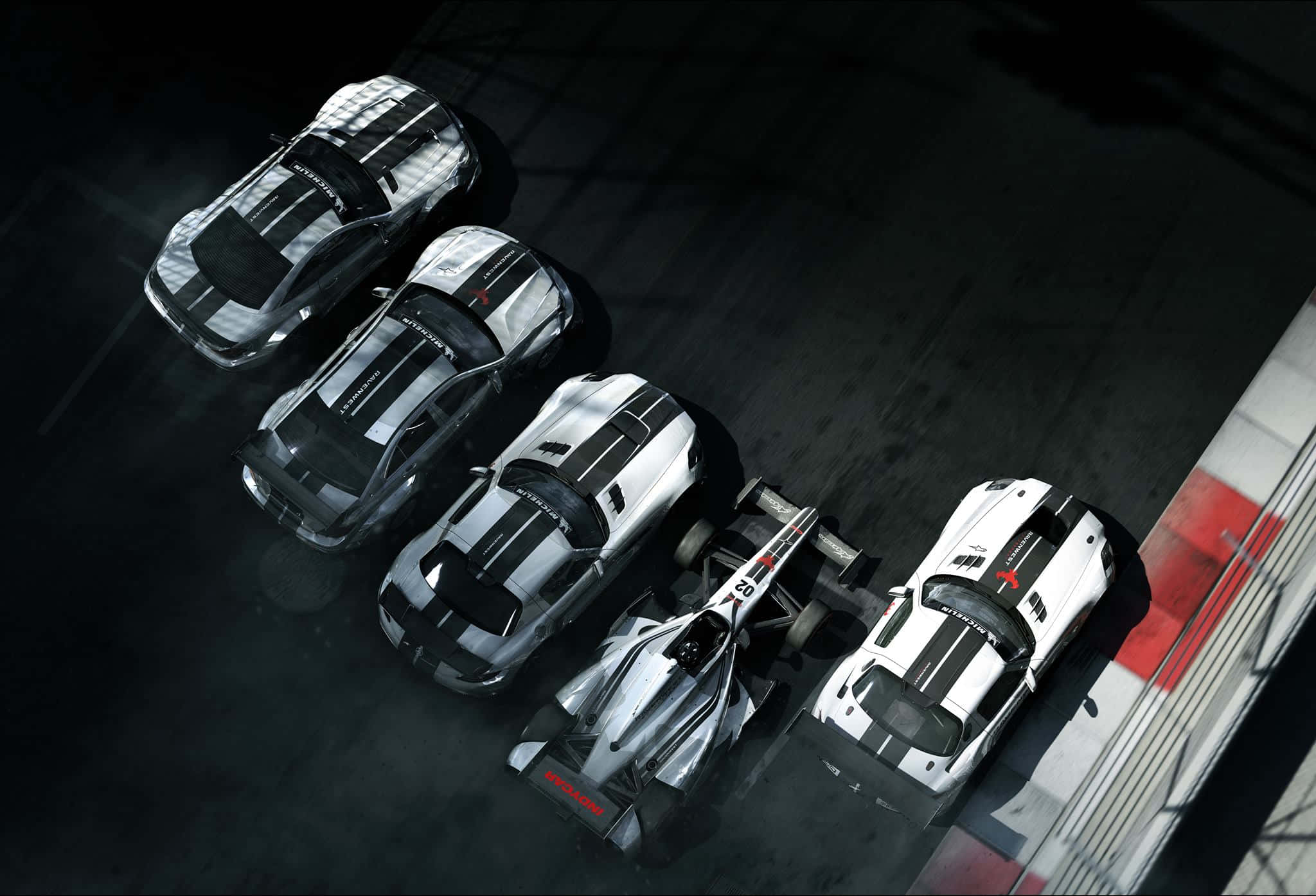 以 Grid Autosport 的聲音為你的螢幕注入動力 壁紙 — 從上方俯瞰五輛高性能賽車排列在帶有紅色和白色路緣的黑暗賽道上。