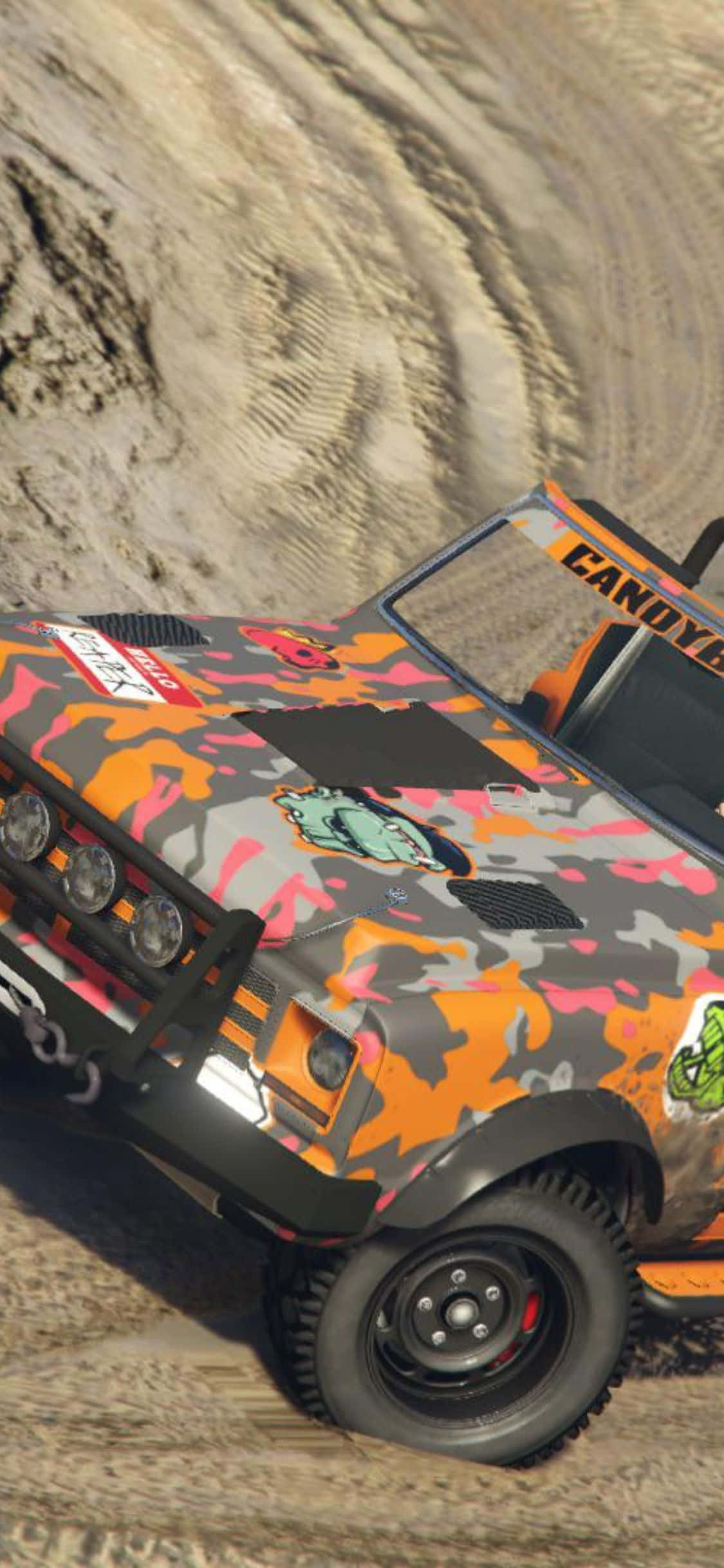 以 iPhone X 為伴，征服《Dirt Rally》 壁紙 — 一輛堅固的越野車，帶有鮮豔的橙色、粉紅色和灰色迷彩塗裝，傾斜在沙丘上。