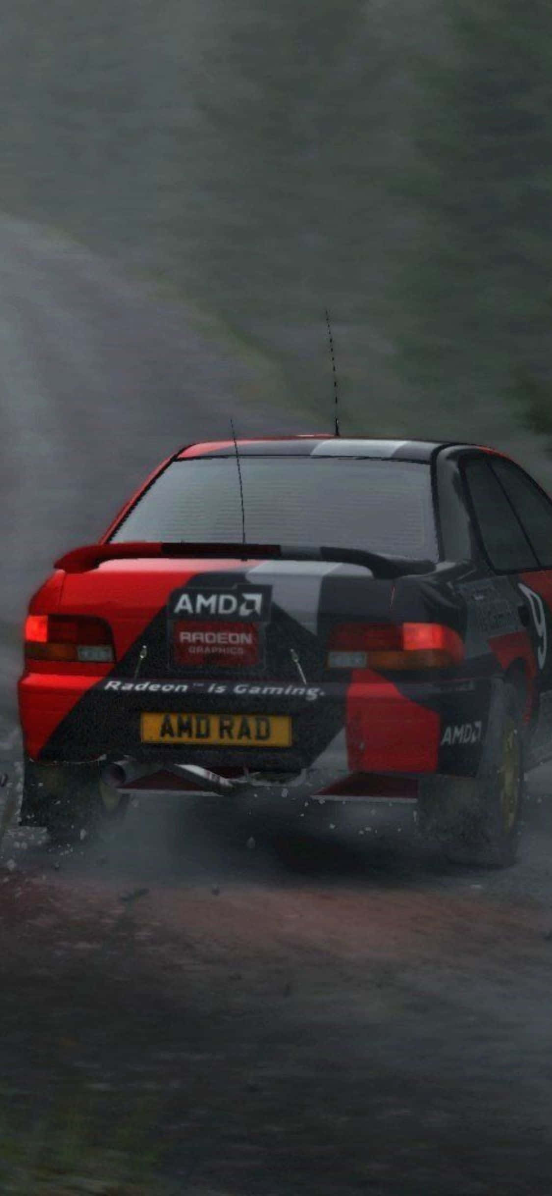 以 iPhone XS Dirt Rally 考驗你的駕駛技巧 壁紙 — 一輛帶有AMD標誌的紅黑色拉力賽車在濕滑的森林賽道上飛馳，濺起水花。
