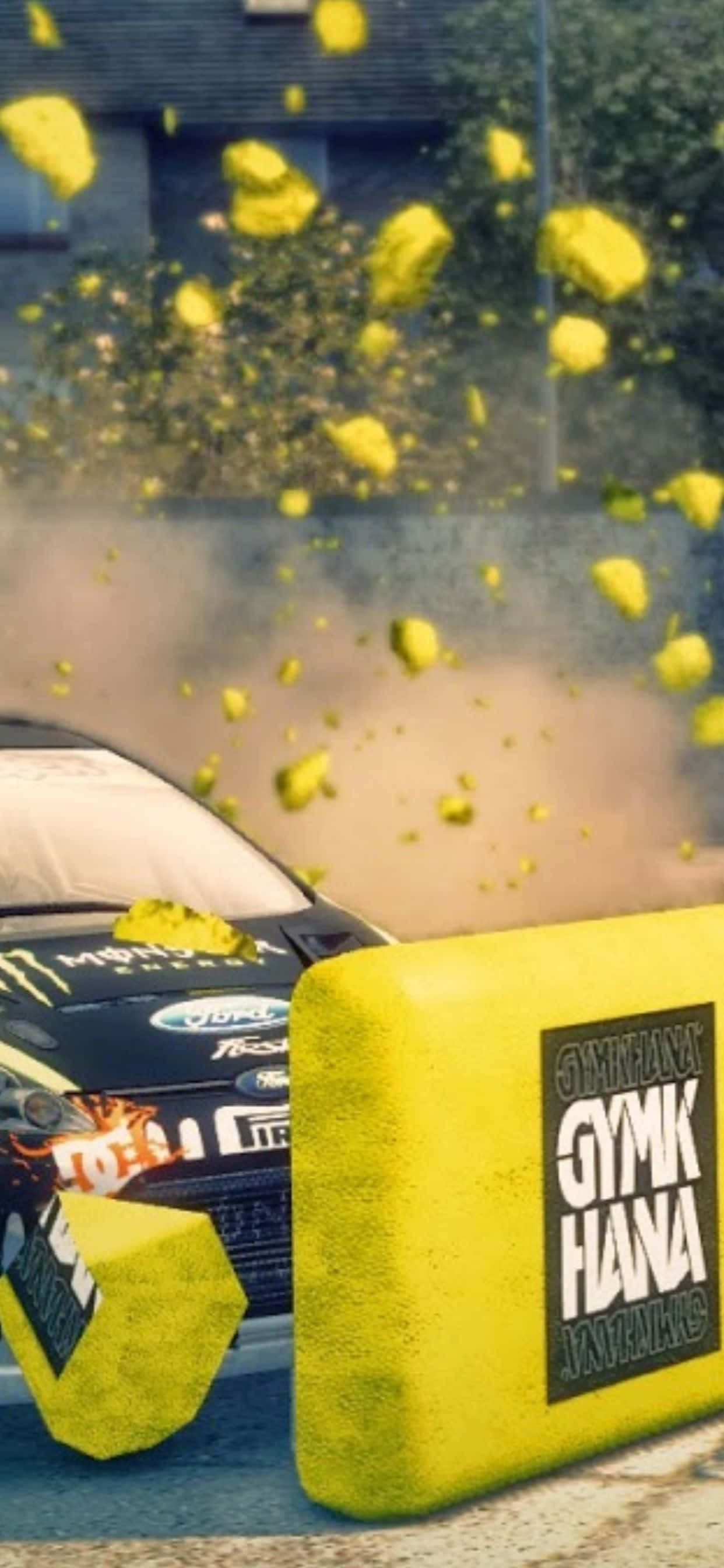 以 iPhone Xs Max 與《Dirt 3》體驗賽車的極致快感 壁紙 — 一輛黑色拉力賽車撞上黃色護欄，在塵土飛揚的城市場景中混凝土塊四處飛濺。