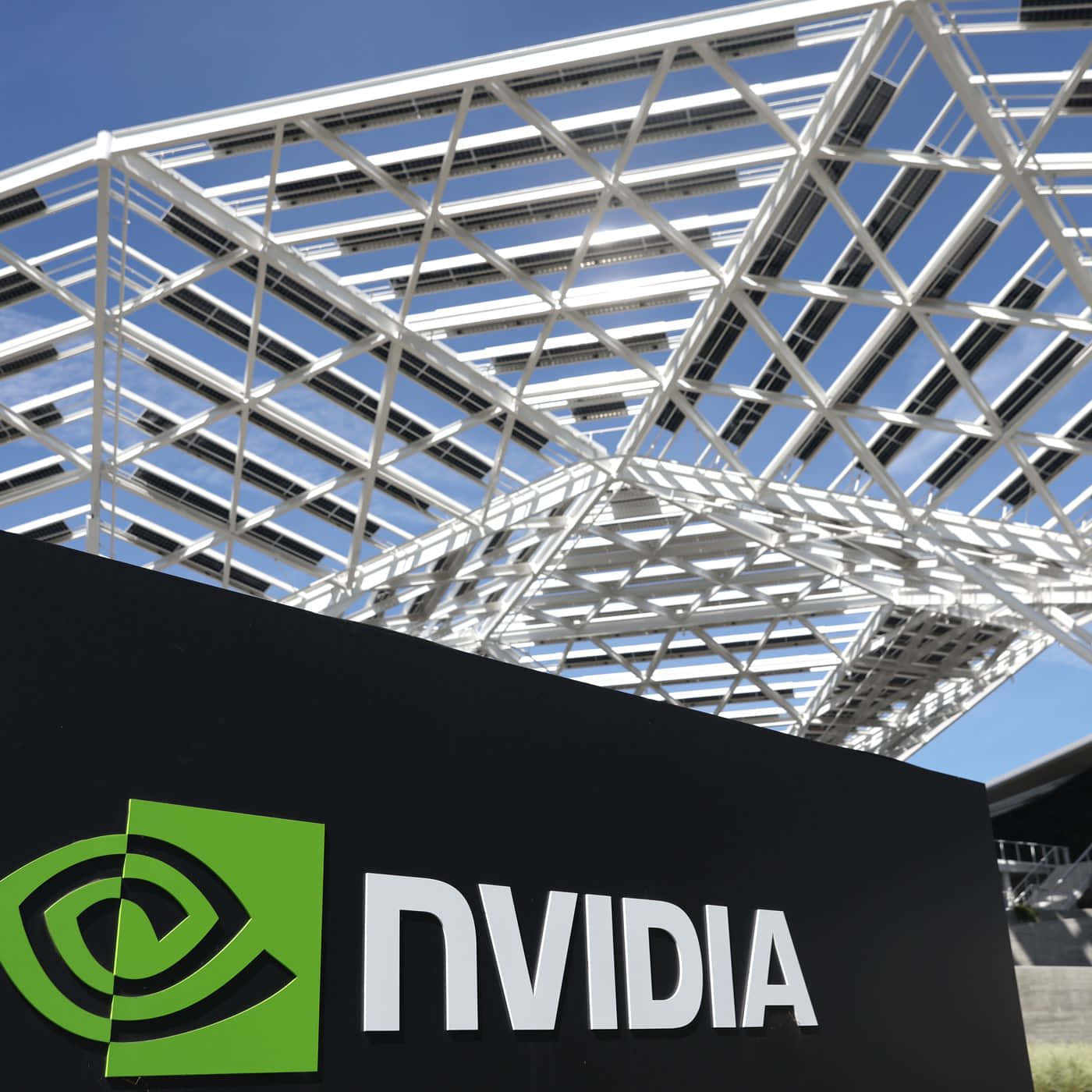 陽光明媚的日子裡，現代太陽能板屋頂下的NVIDIA標誌。