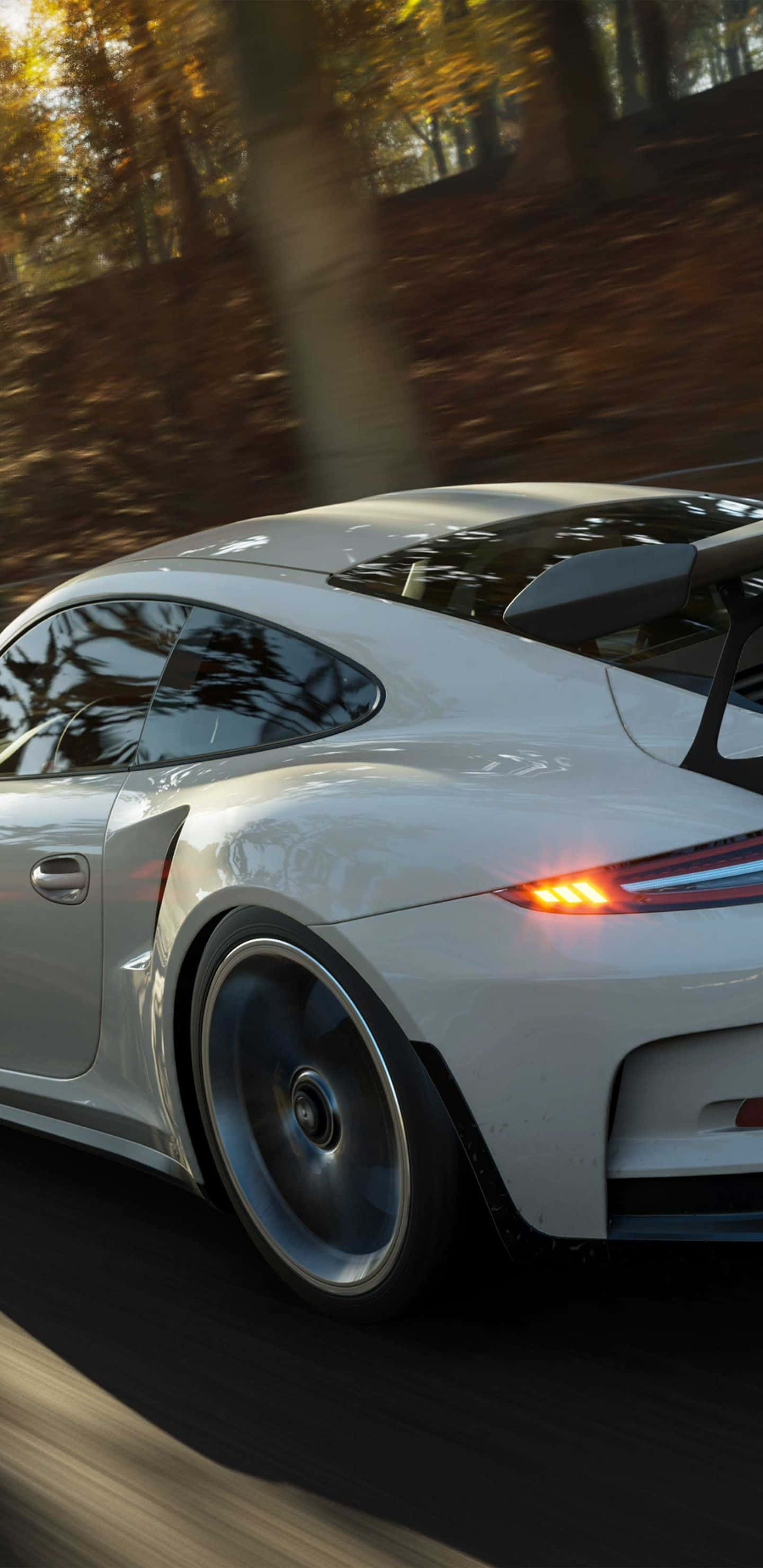 以 Pixel 3xL 和 Forza Horizon 4 領先競速 壁紙 — 一輛白色保時捷911 GT3 RS在金色的秋林中疾馳，帶有模糊的動態和發光的尾燈。