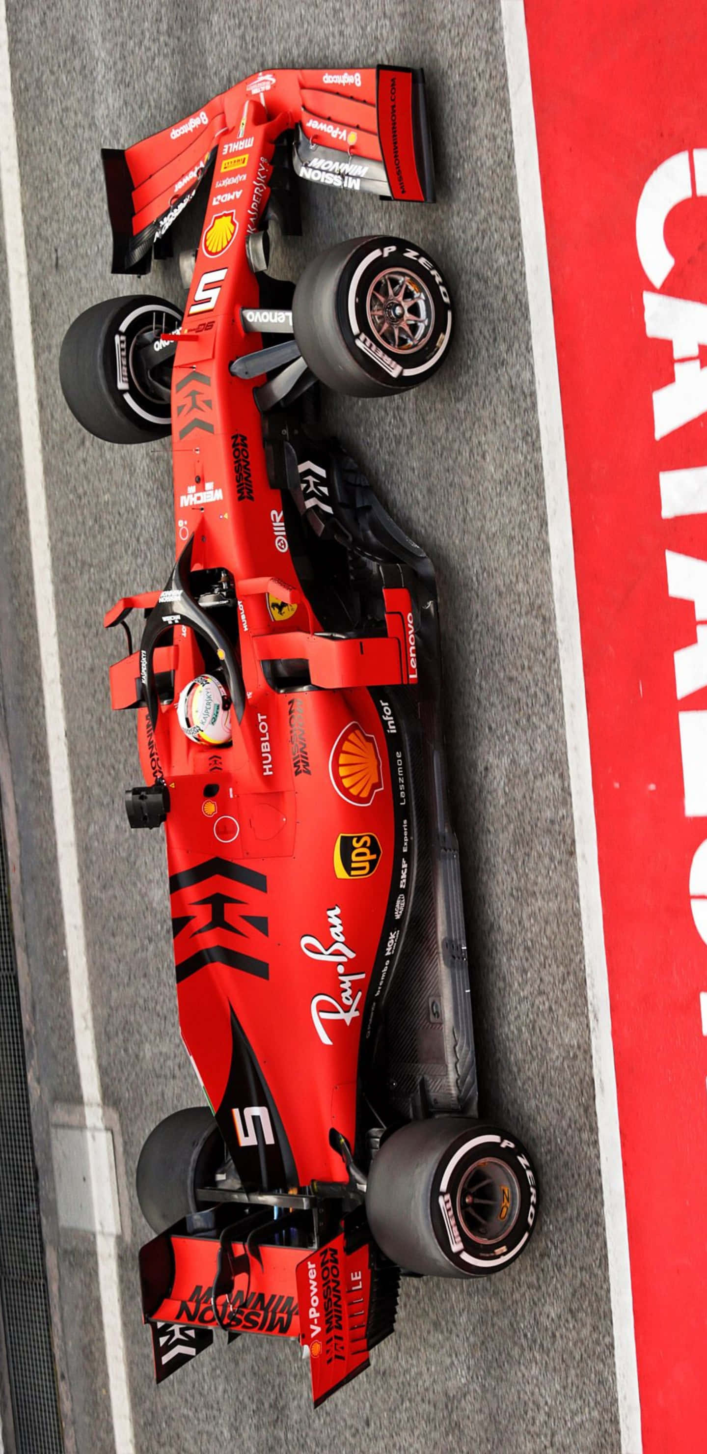 以 Pixel 3xl 激情迎接 F1 2019 壁紙 — 從上方俯瞰紅色法拉利一級方程式賽車在賽道上，賽道有紅色牆壁和白色線條。
