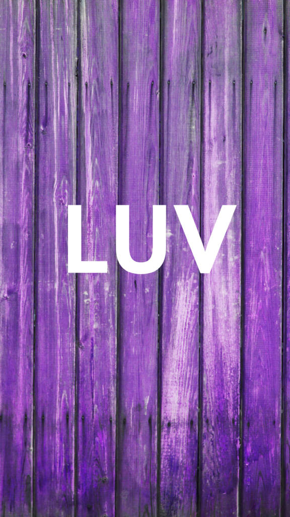 紫色木牆上寫有白色文字 LUV