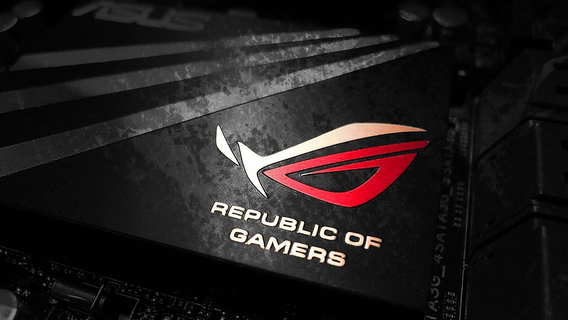 以 ROG 將遊戲體驗提升至另一層次 壁紙 — ASUS ROG Republic of Gamers 標誌在帶有紋理的黑色遊戲主機板上發出紅色和白色光芒的特寫。