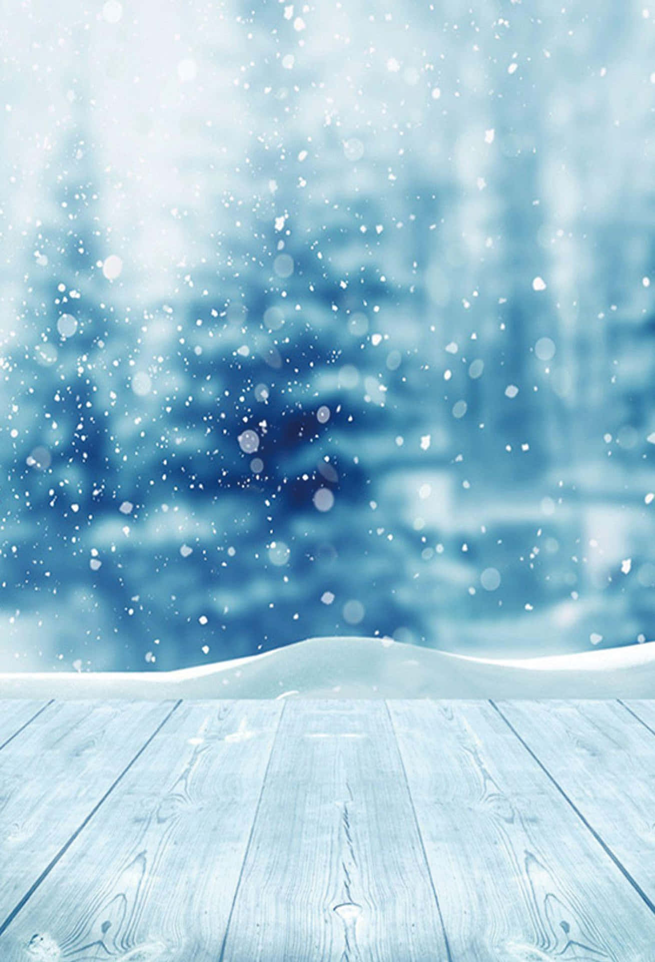 雪落在雪林中的木甲板上