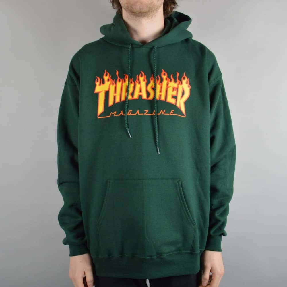 穿著綠色連帽衛衣的人，帶有橙色火焰風格Thrasher Magazine標誌。