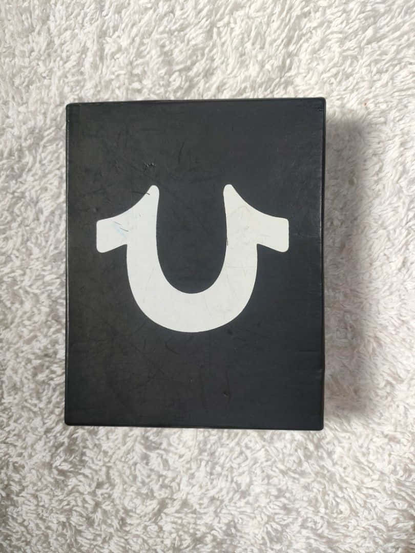 黑色盒子帶白色U標誌，置於毛絨白色背景上