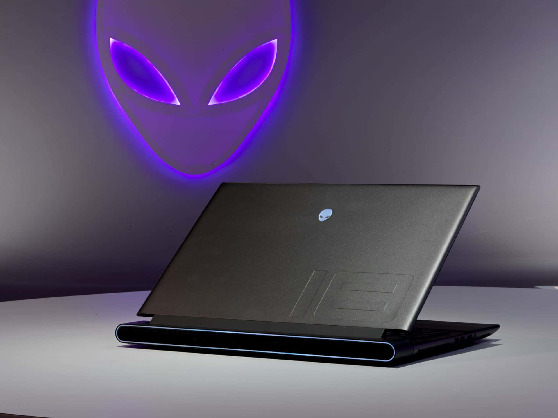 Alienware手提電腦，背後牆上有發光的外星人標誌
