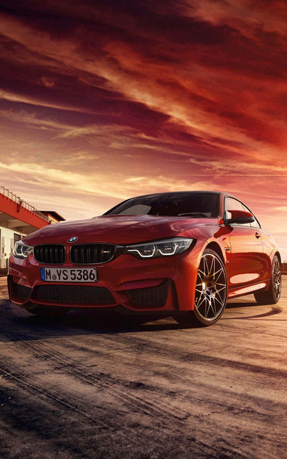 紅色BMW M4跑車在黃昏時分停泊，天空壯麗