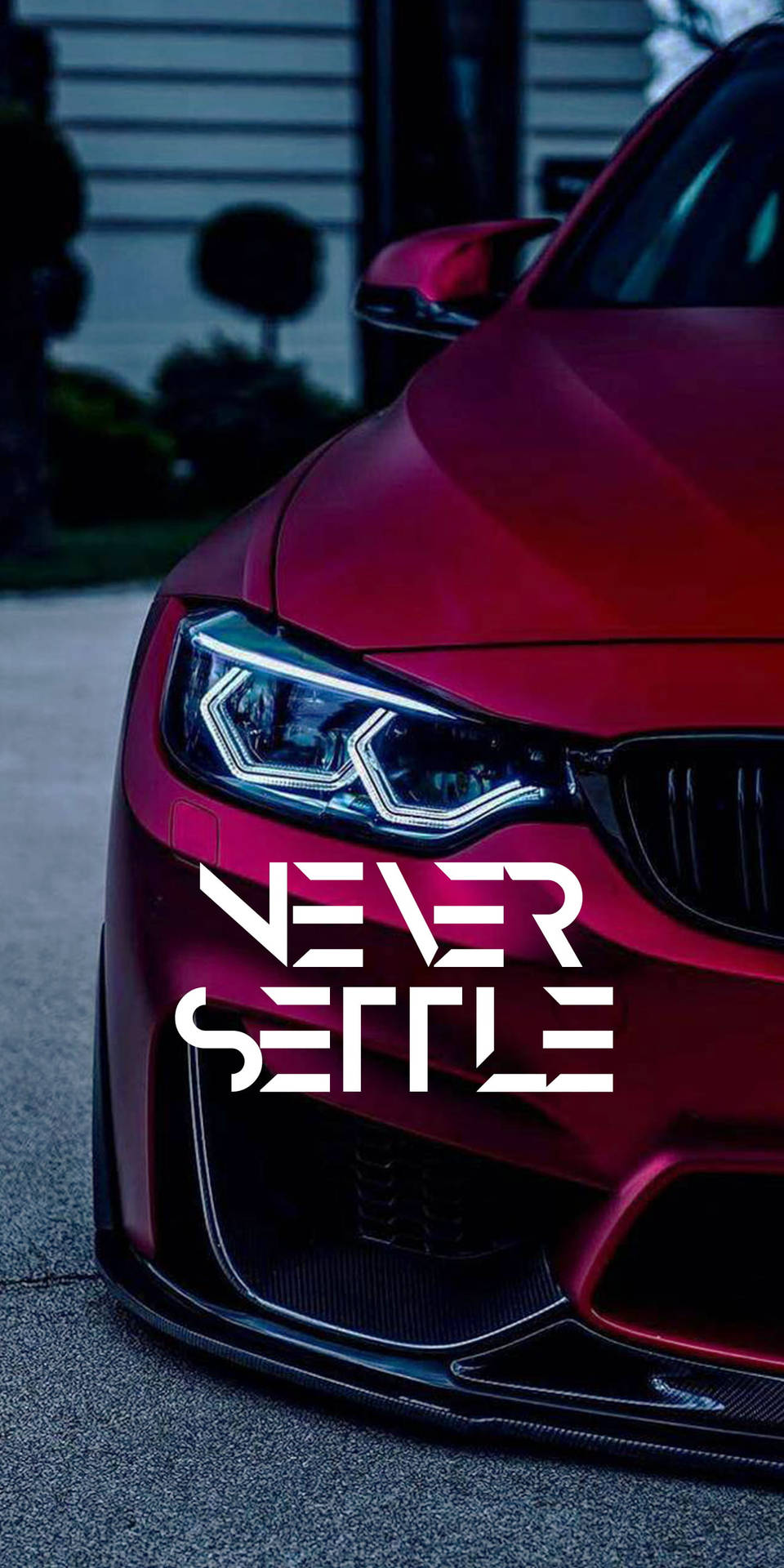 紅色跑車帶有'Never Settle'文字，在黃昏時停放。