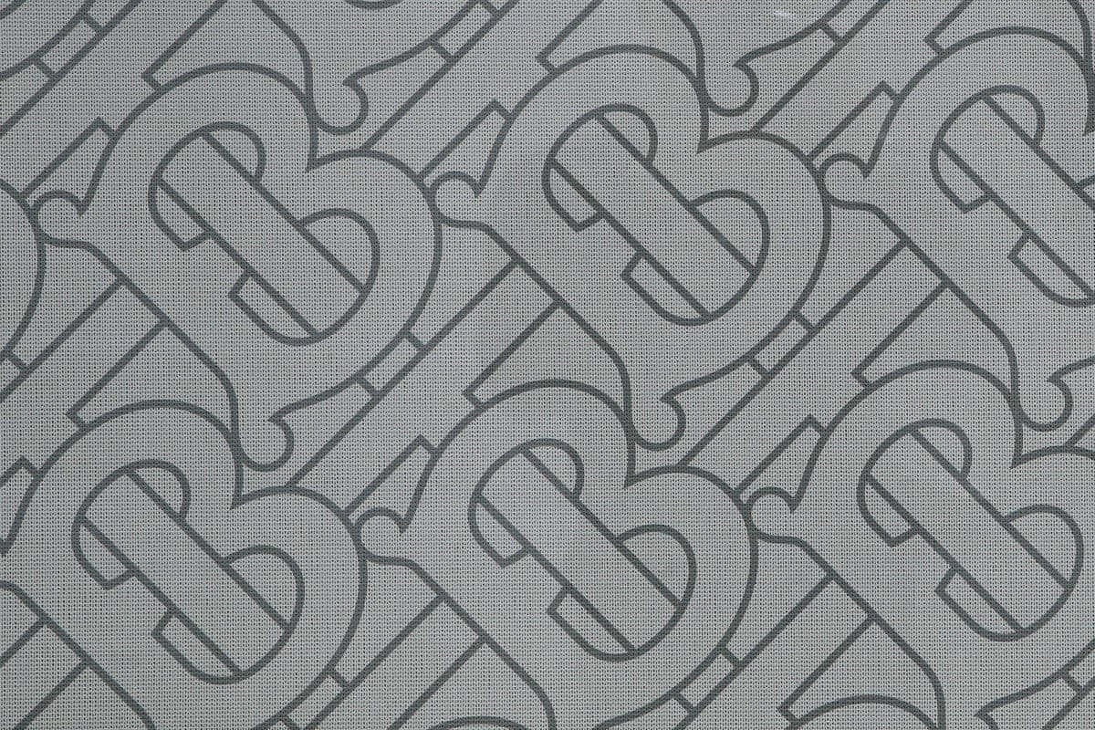 帶有重複交織B字母組合圖案的灰色布料。
