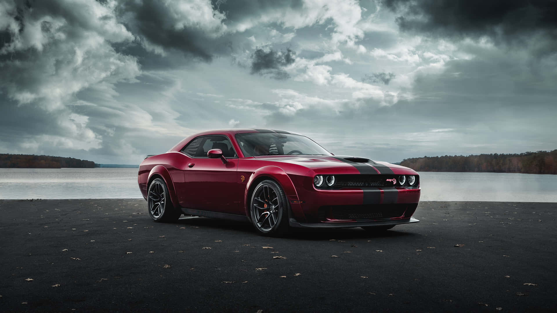紅色Dodge Challenger停喺湖邊，天空風暴密佈。