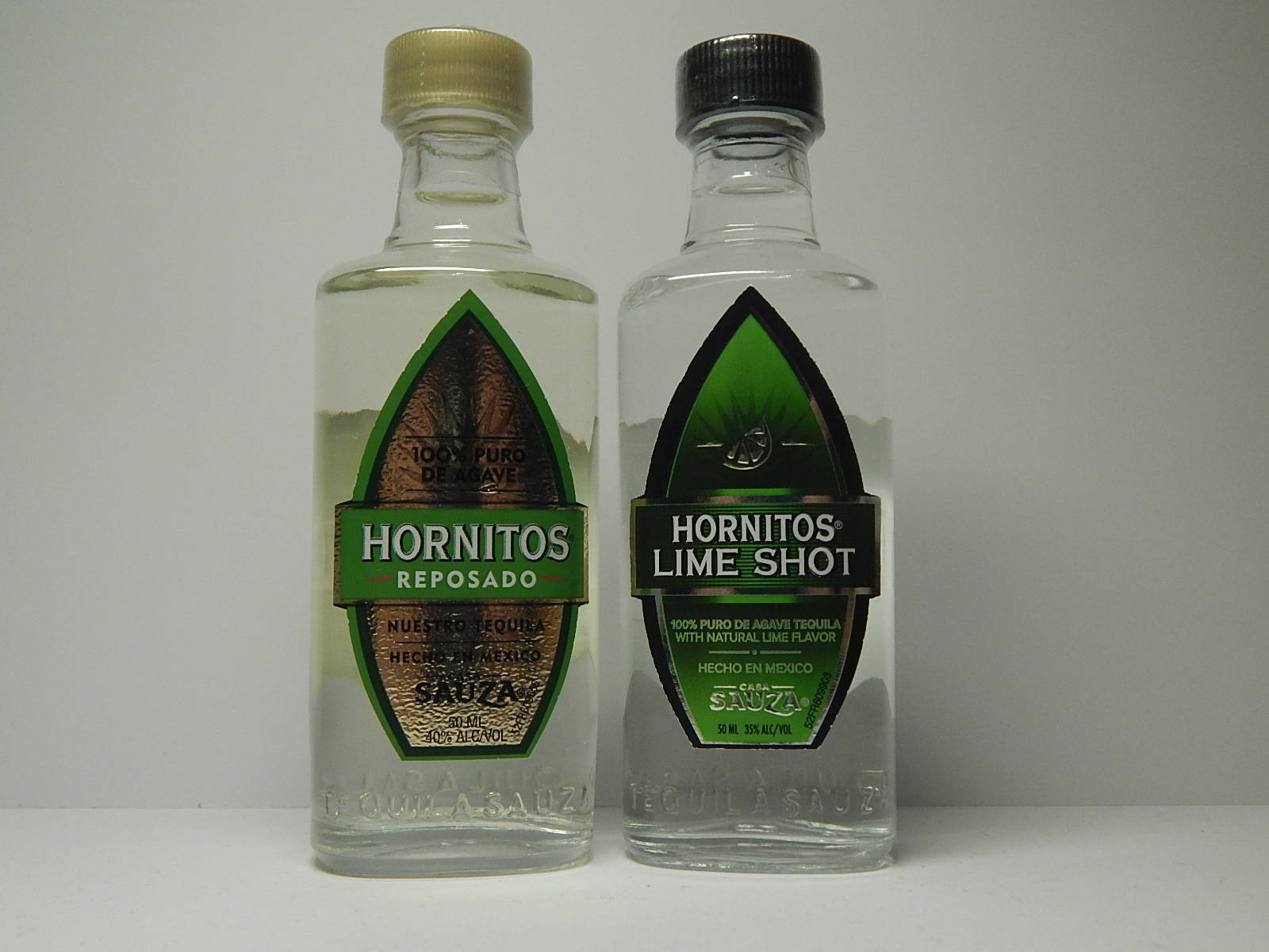 白色表面上兩瓶Hornitos龍舌蘭酒，一瓶是reposado，一瓶是青檸shot。