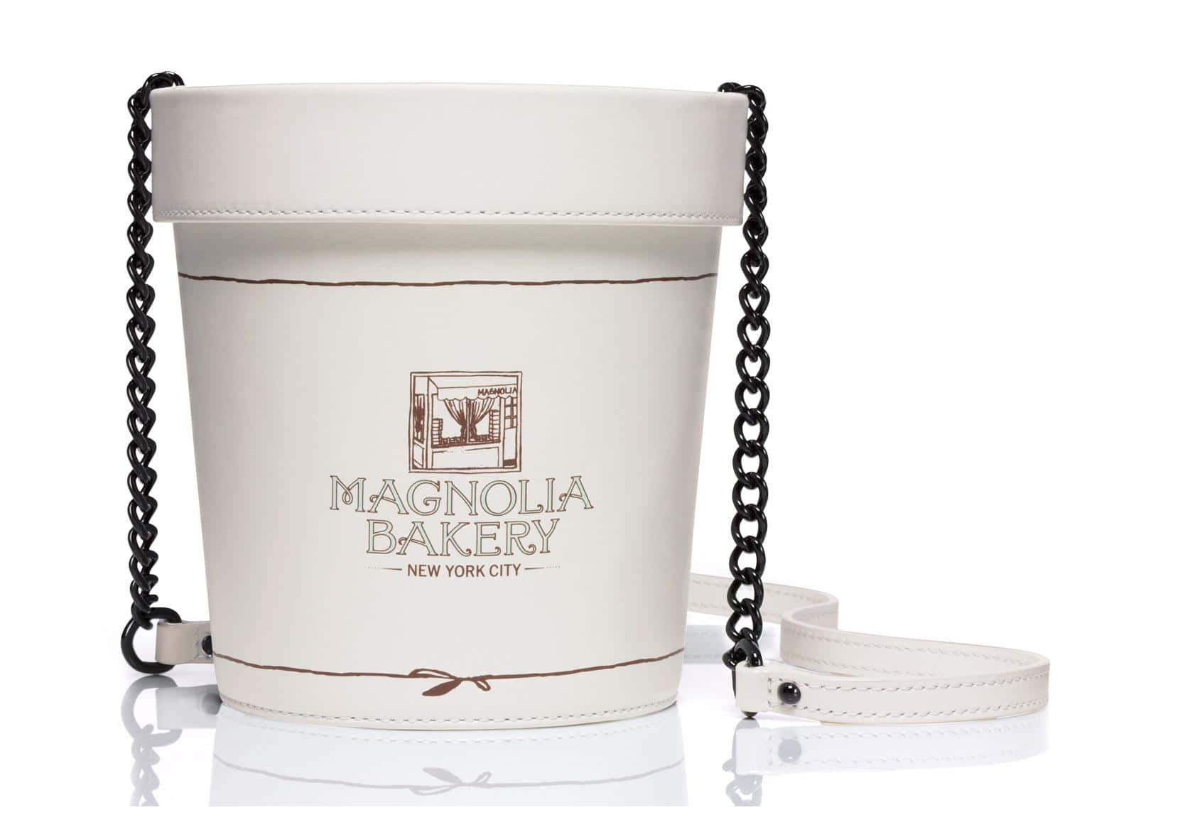 白色水桶手袋，黑色鏈條肩帶，Magnolia Bakery 標誌。