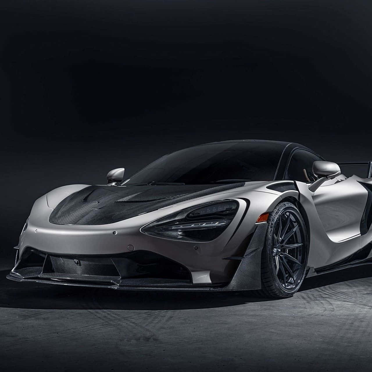 銀色McLaren Senna超級跑車在黑暗的攝影棚環境中帶有碳纖維細節。