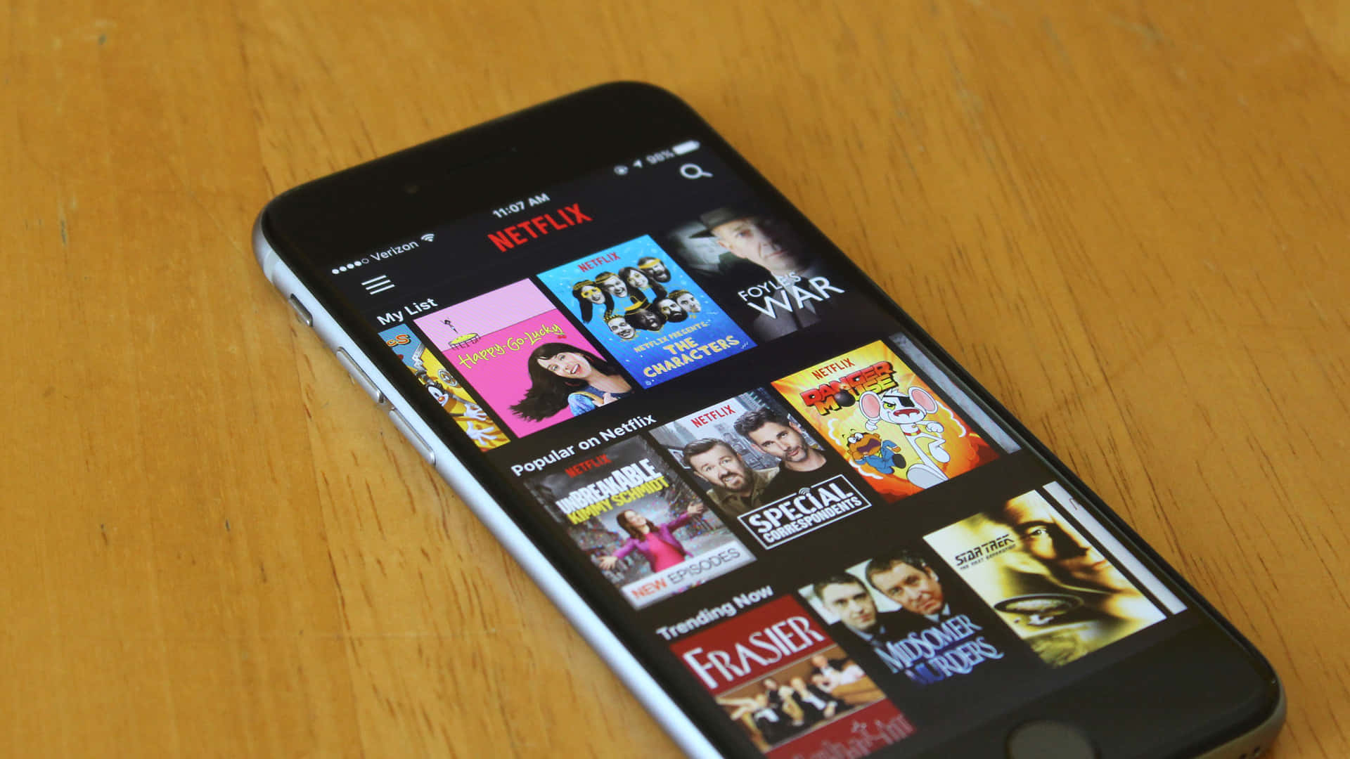 智能手機在木桌上顯示Netflix應用程式
