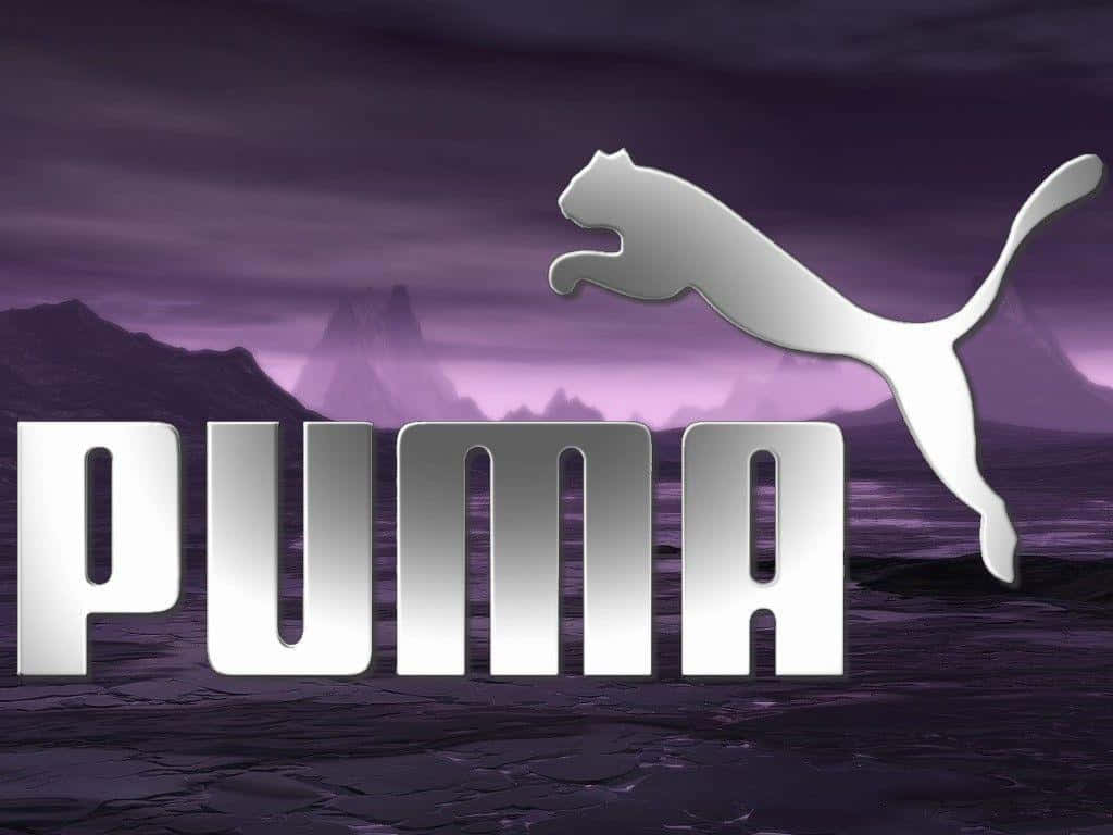 以Puma準備贏得勝利 壁紙 — 一個銀色Puma標誌，帶有跳躍的貓剪影，在戲劇性的紫色山脈背景下大膽突出。