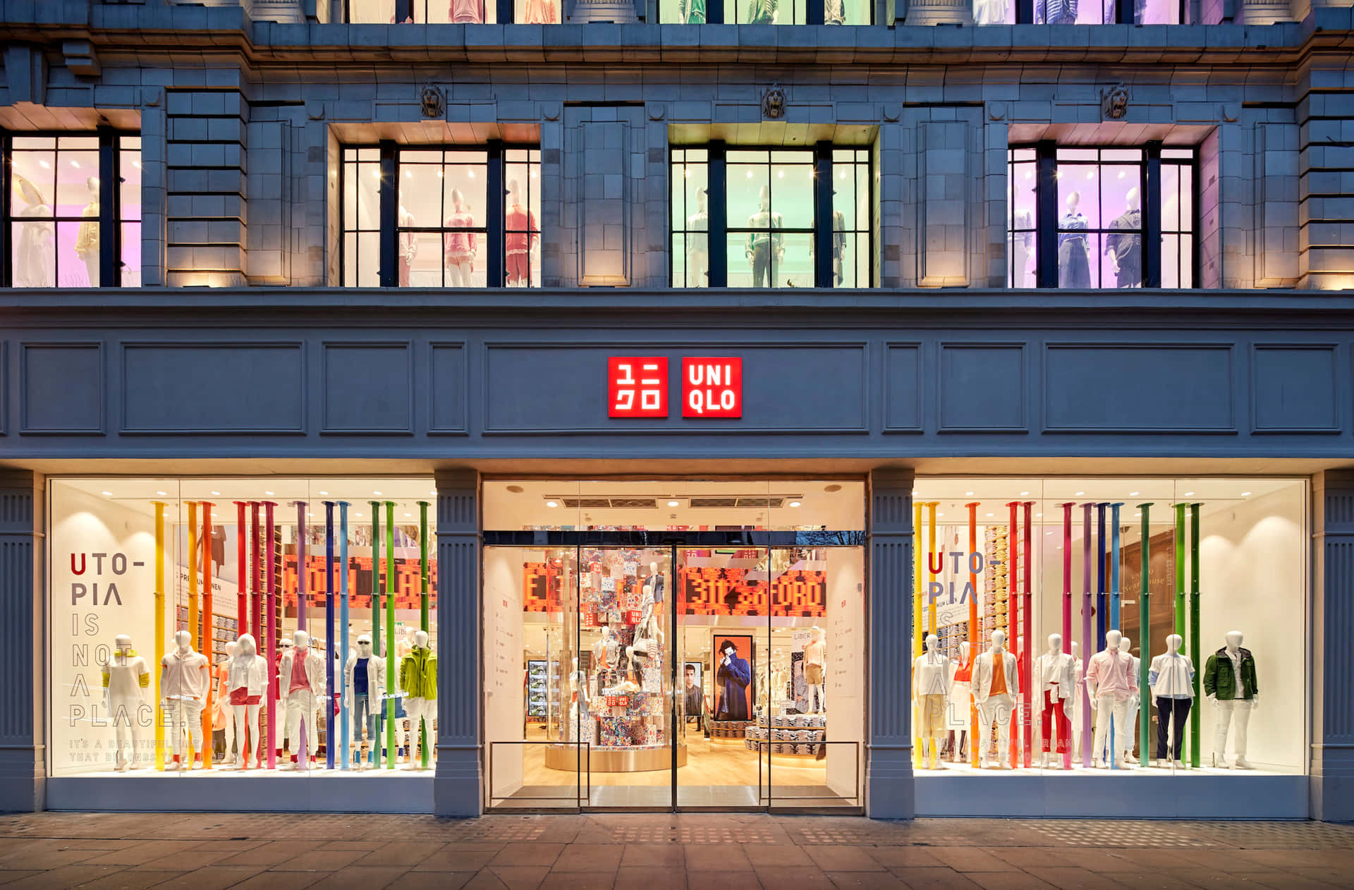 夜晚的 Uniqlo 商店正面，櫥窗內有彩色展示和人體模型。