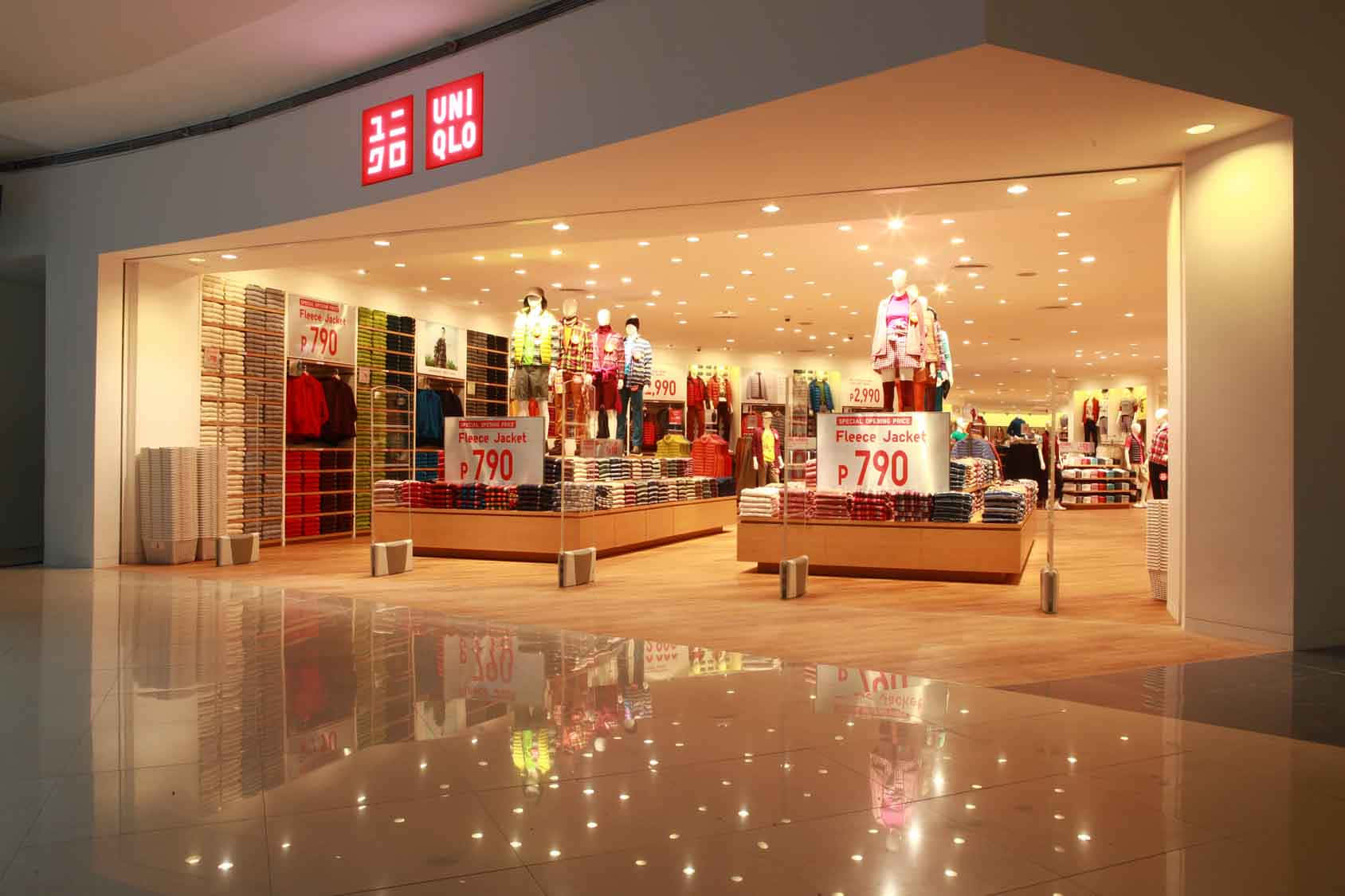 Uniqlo店舖入口，人體模型和價格標籤映照在閃亮的地磚上。