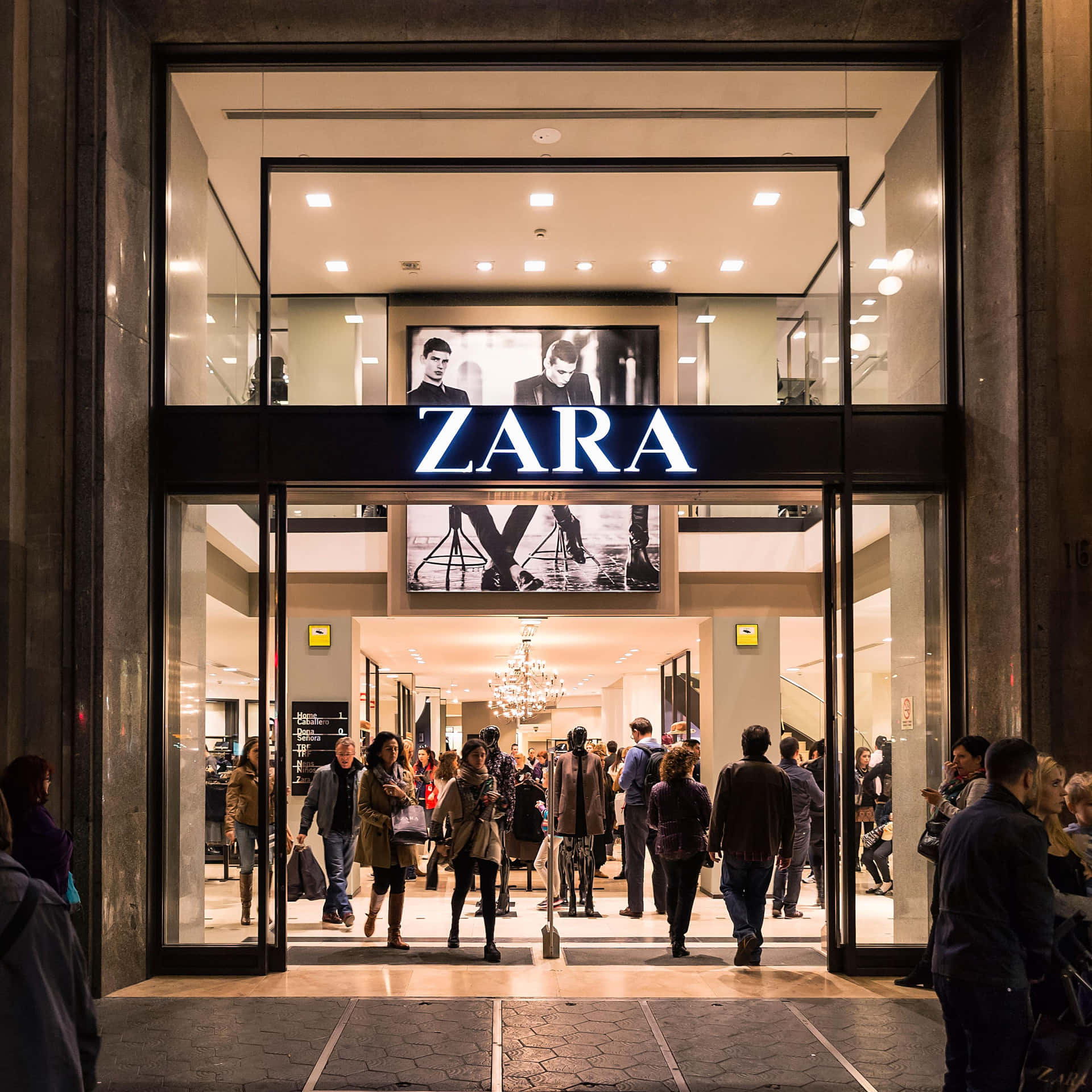 夜晚的Zara店舖入口，購物者進出。